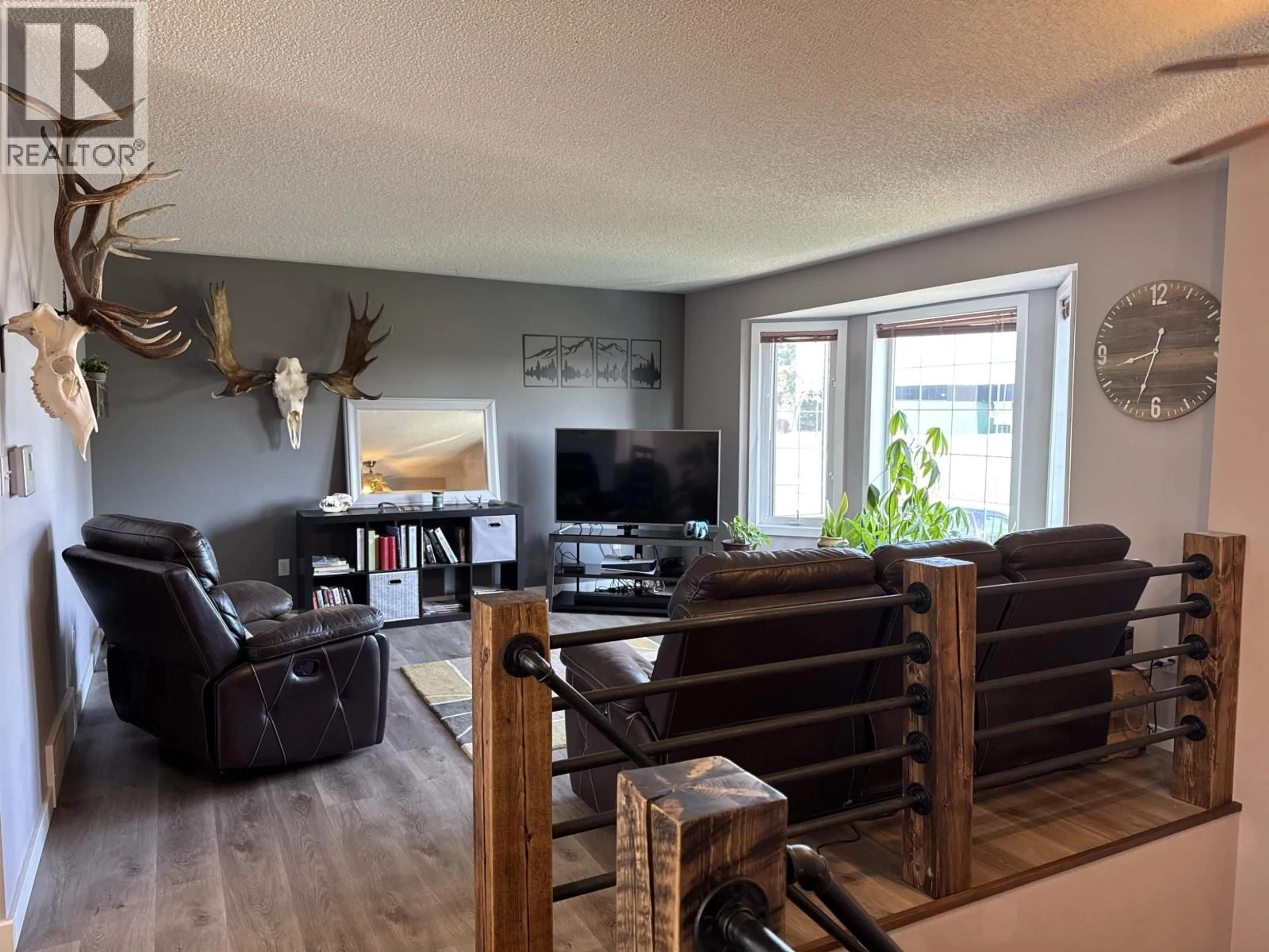 Living room with furniture, wood/laminate floor for 9011 107 AVENUE, Fort St. John British Columbia V1J2P1