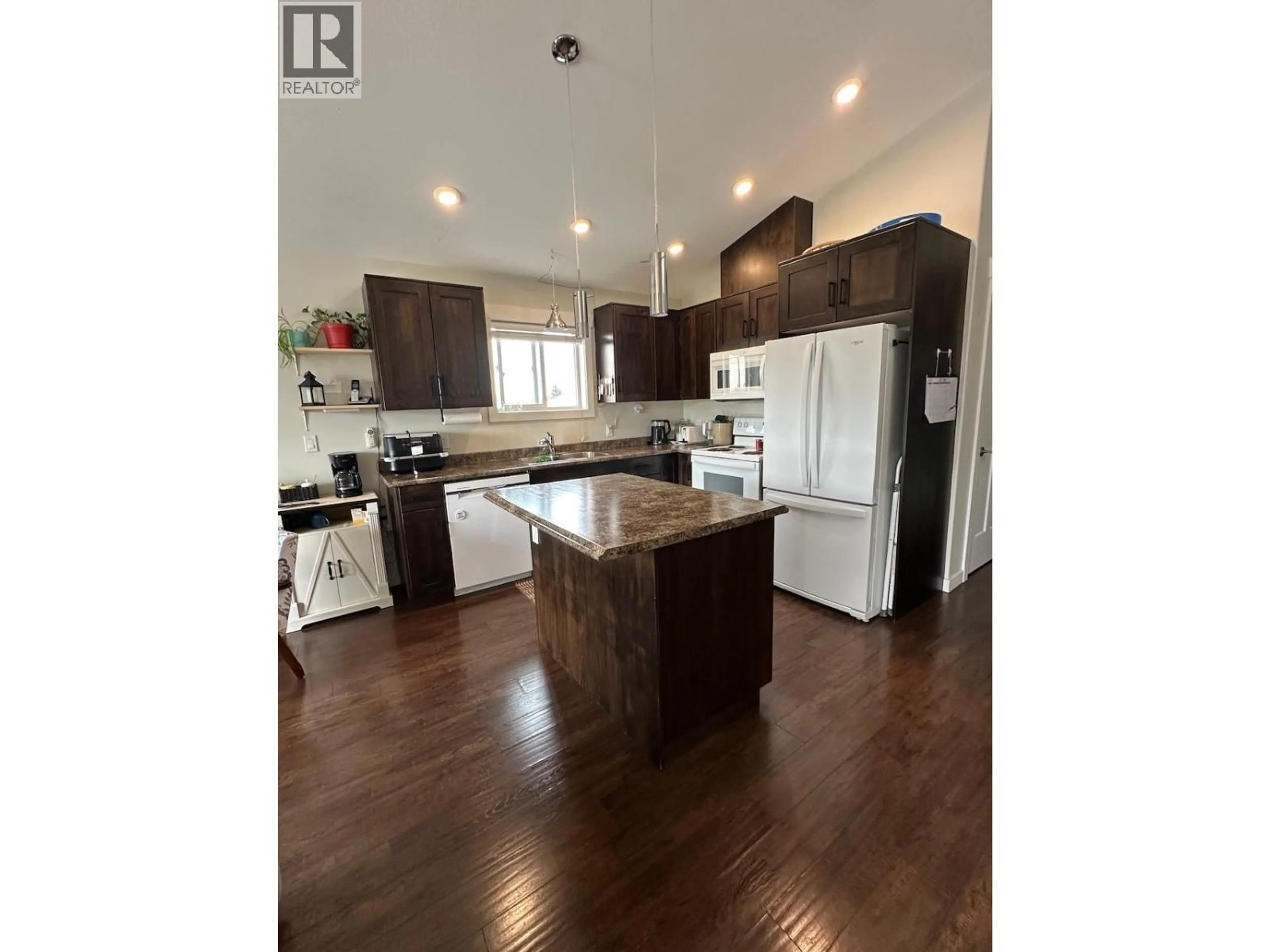 Open concept kitchen, wood/laminate floor for 8724 77 STREET, Fort St. John British Columbia V1J3A3
