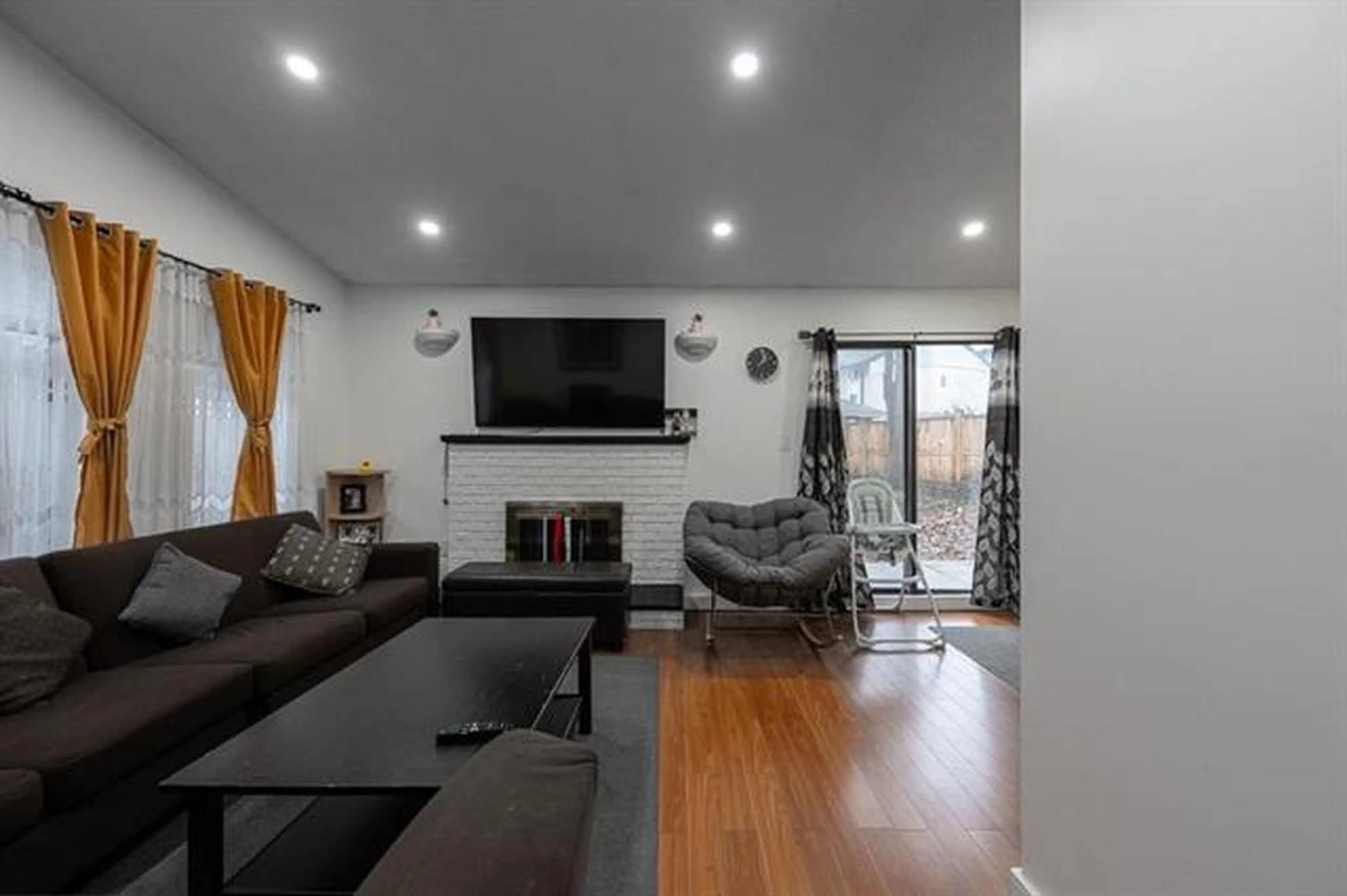 Living room with furniture, wood/laminate floor for 7366 128A STREET, Surrey British Columbia V3W7G9