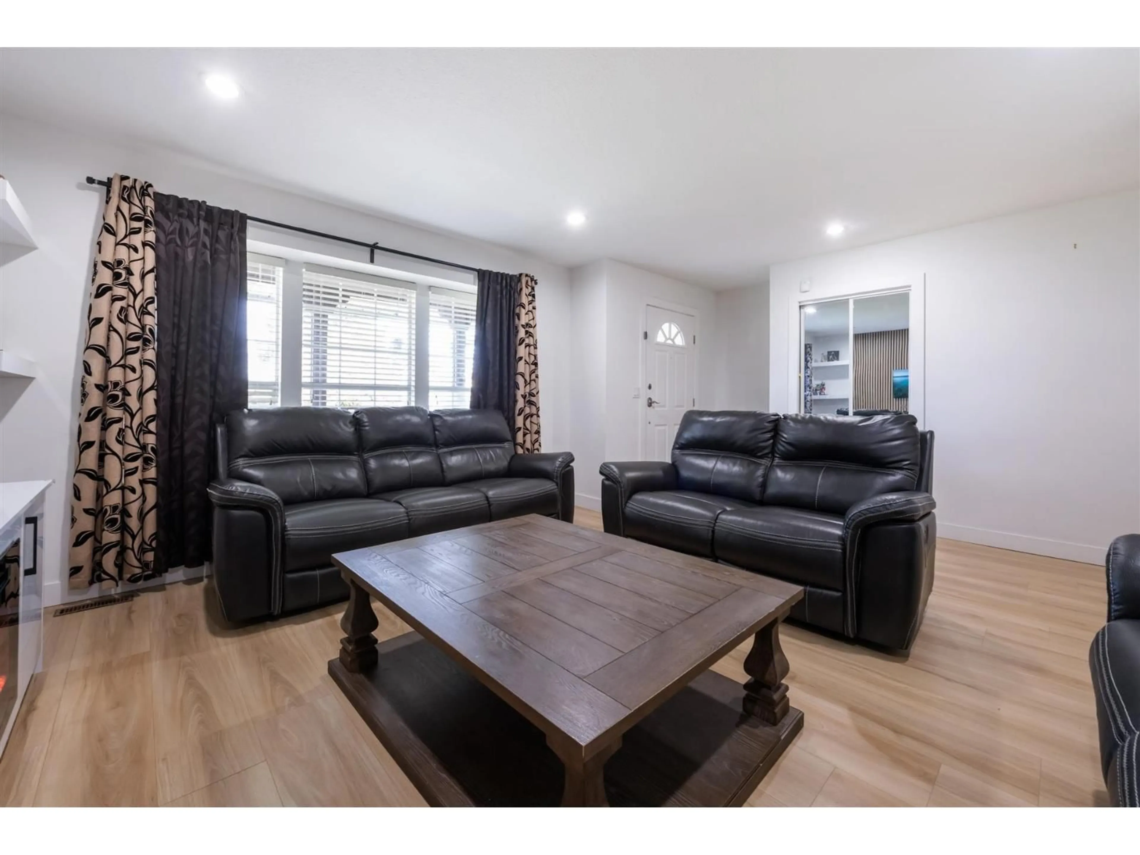 Living room with furniture, wood/laminate floor for 16954 60 AVENUE, Surrey British Columbia V3S1T2
