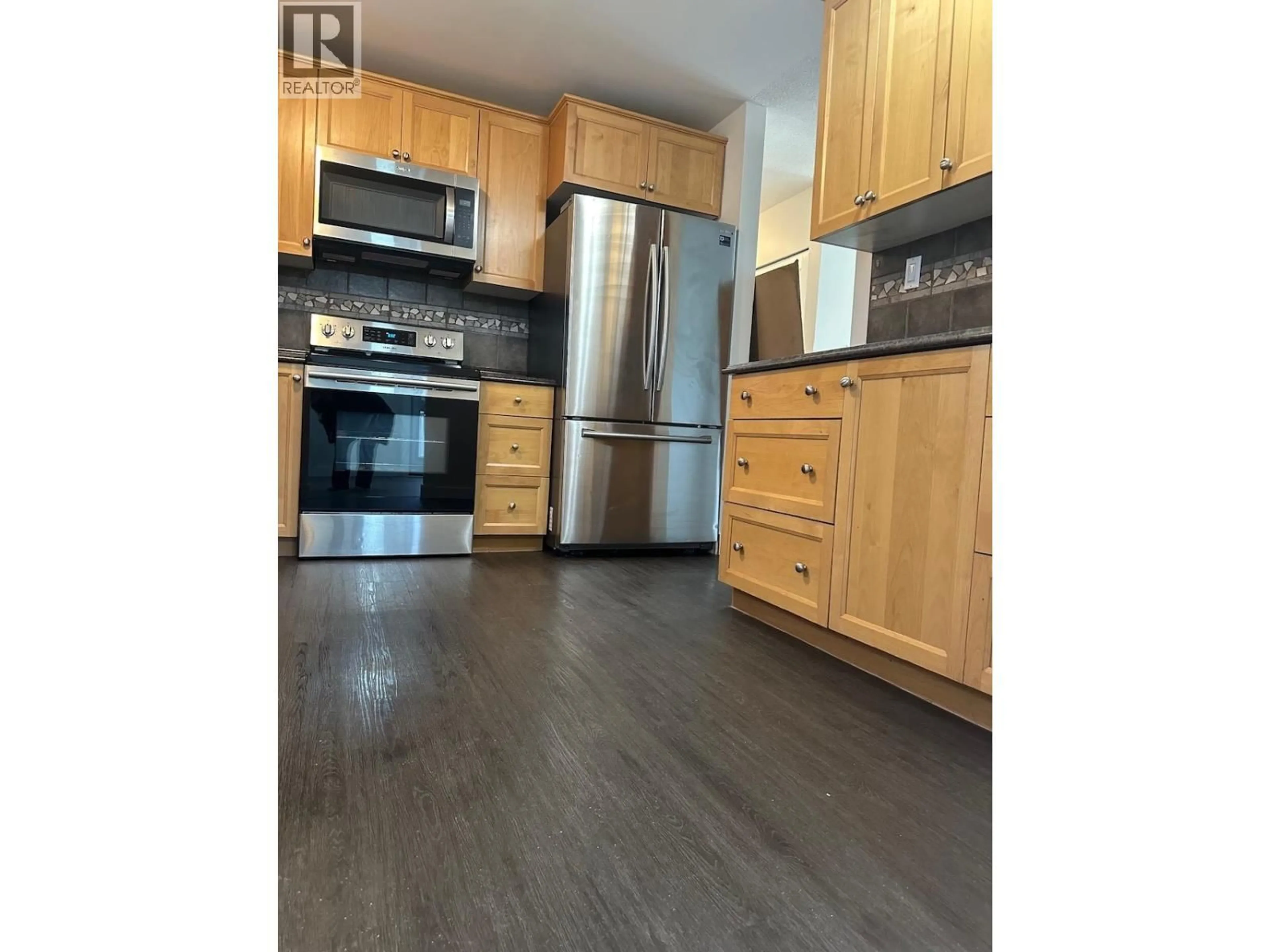 Open concept kitchen, wood/laminate floor for 9015 91 AVENUE, Fort St. John British Columbia V1J4W3