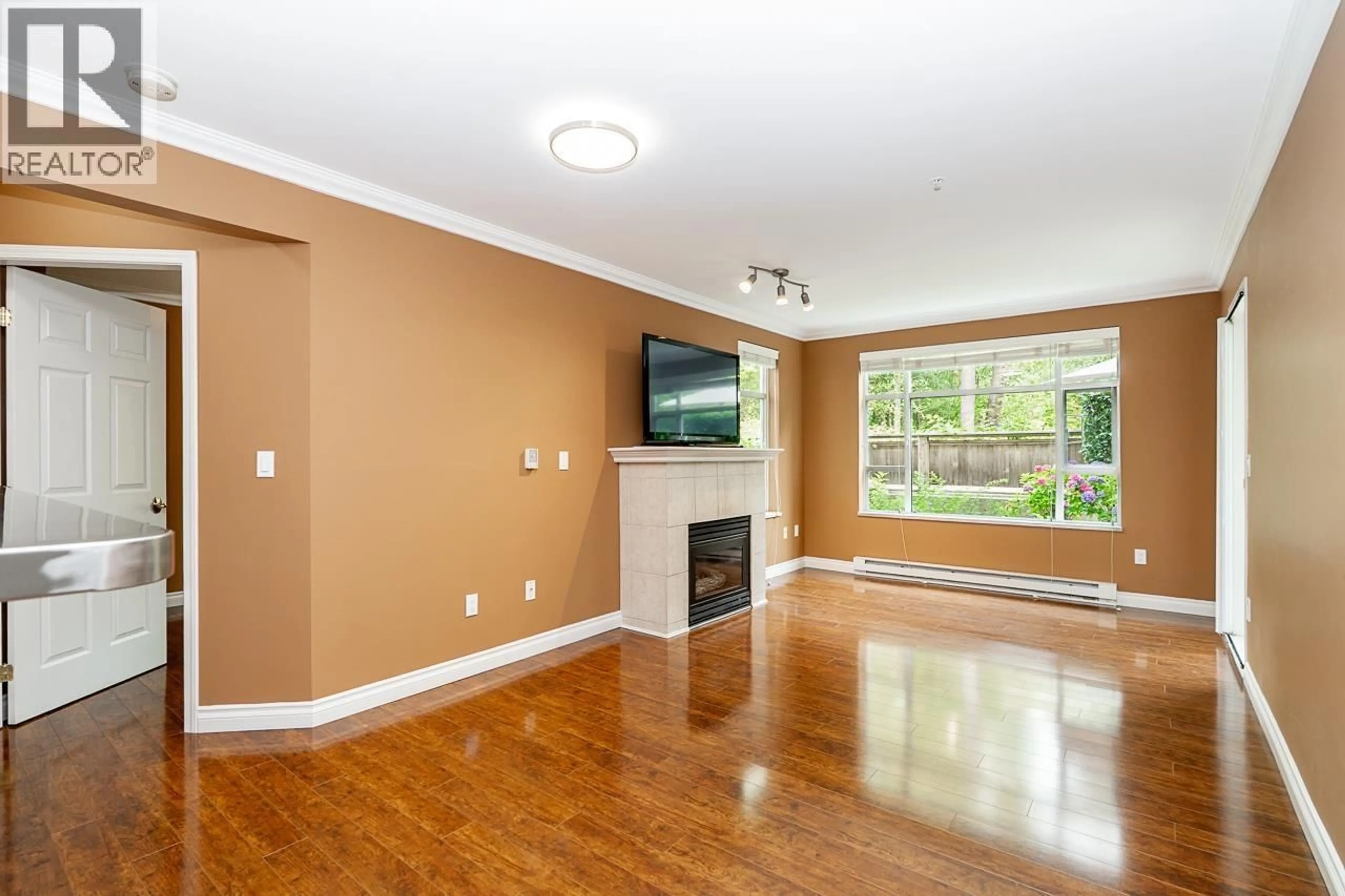 Living room with furniture, wood/laminate floor for 103 - 3625 WINDCREST DRIVE, North Vancouver British Columbia V7G2S6
