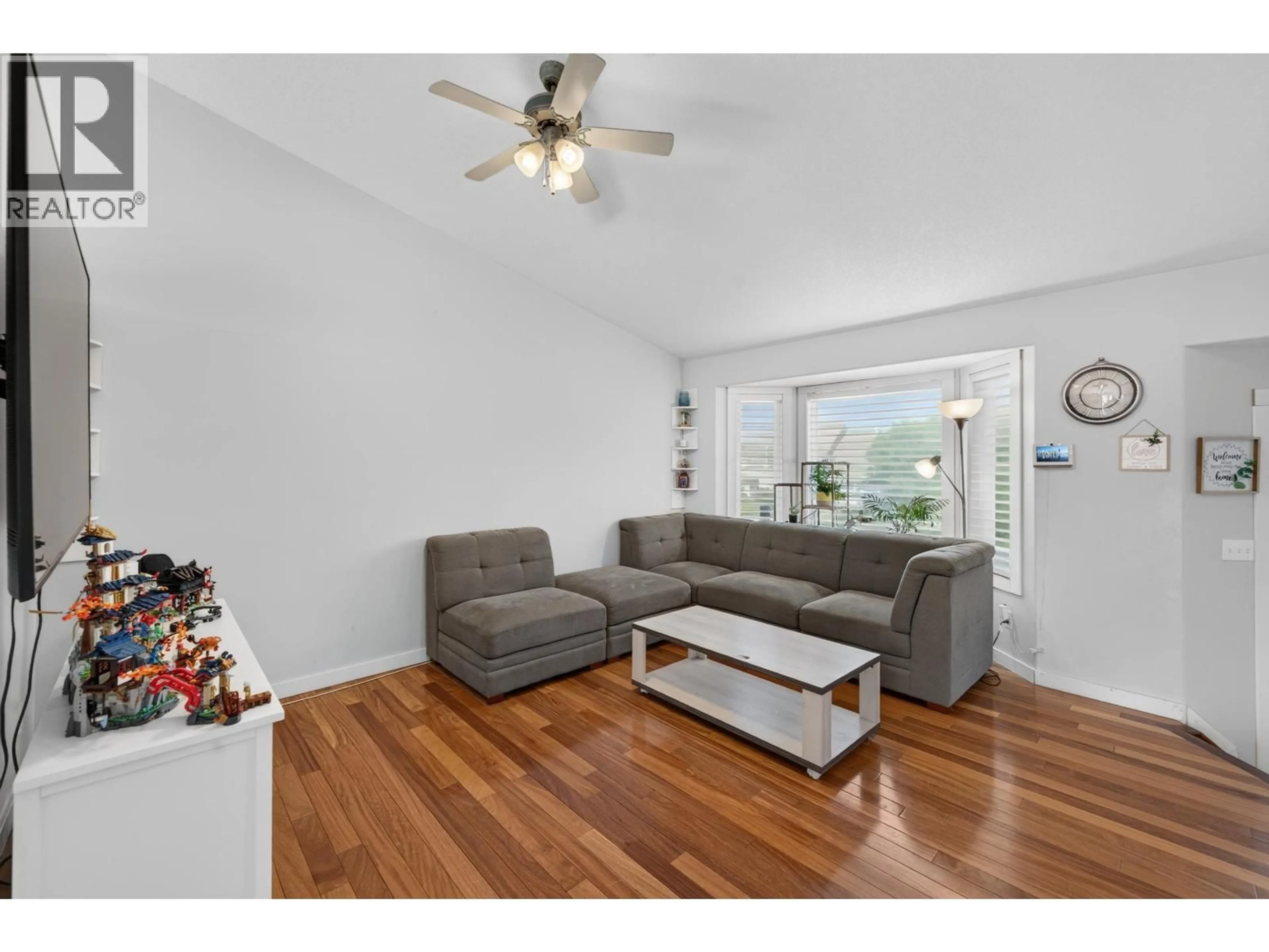 Living room with furniture, wood/laminate floor for 9007 112 AVENUE, Fort St. John British Columbia V1J6G2