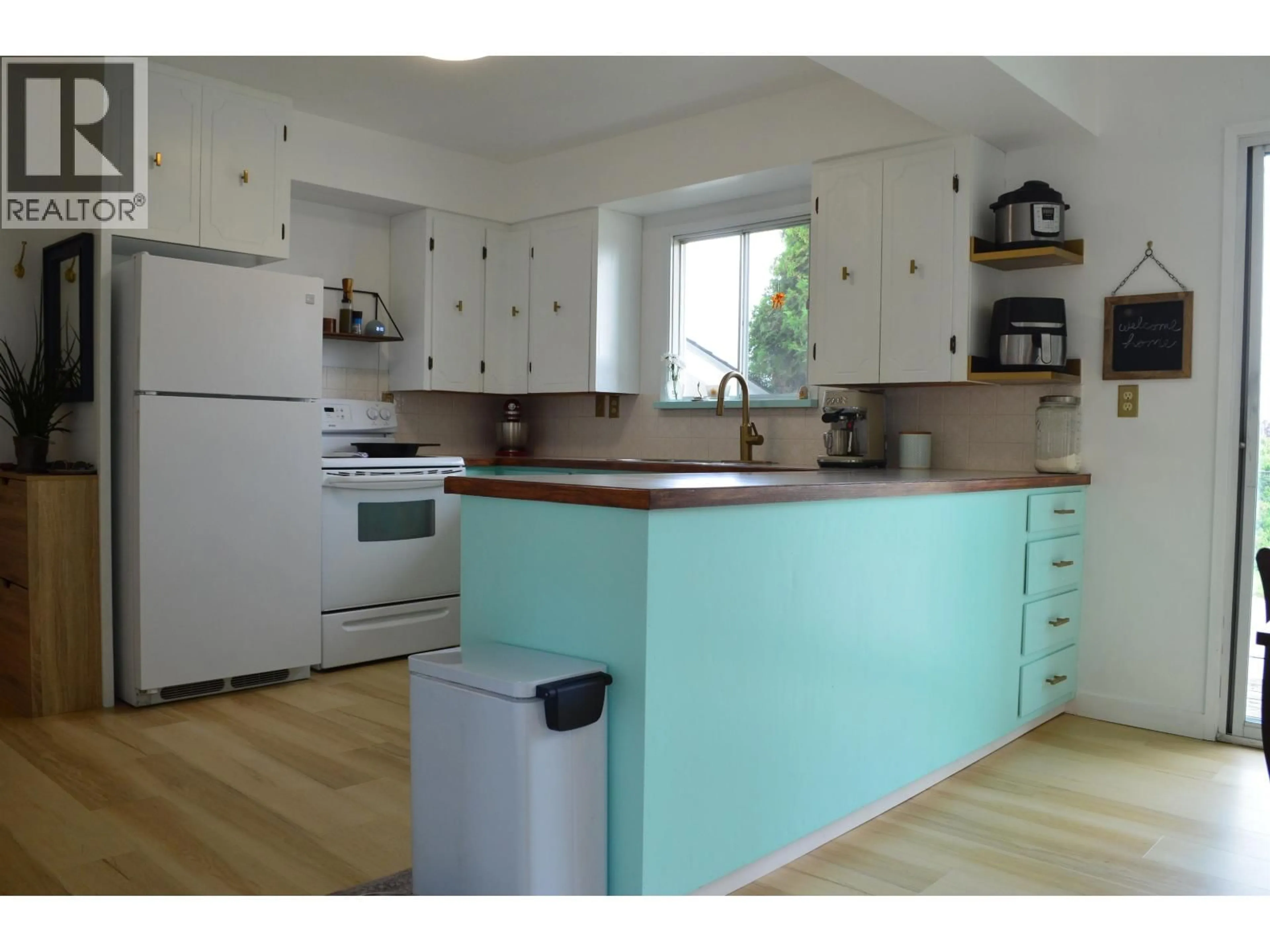 Open concept kitchen, wood/laminate floor for 9404 84 STREET, Fort St. John British Columbia V1J3E4