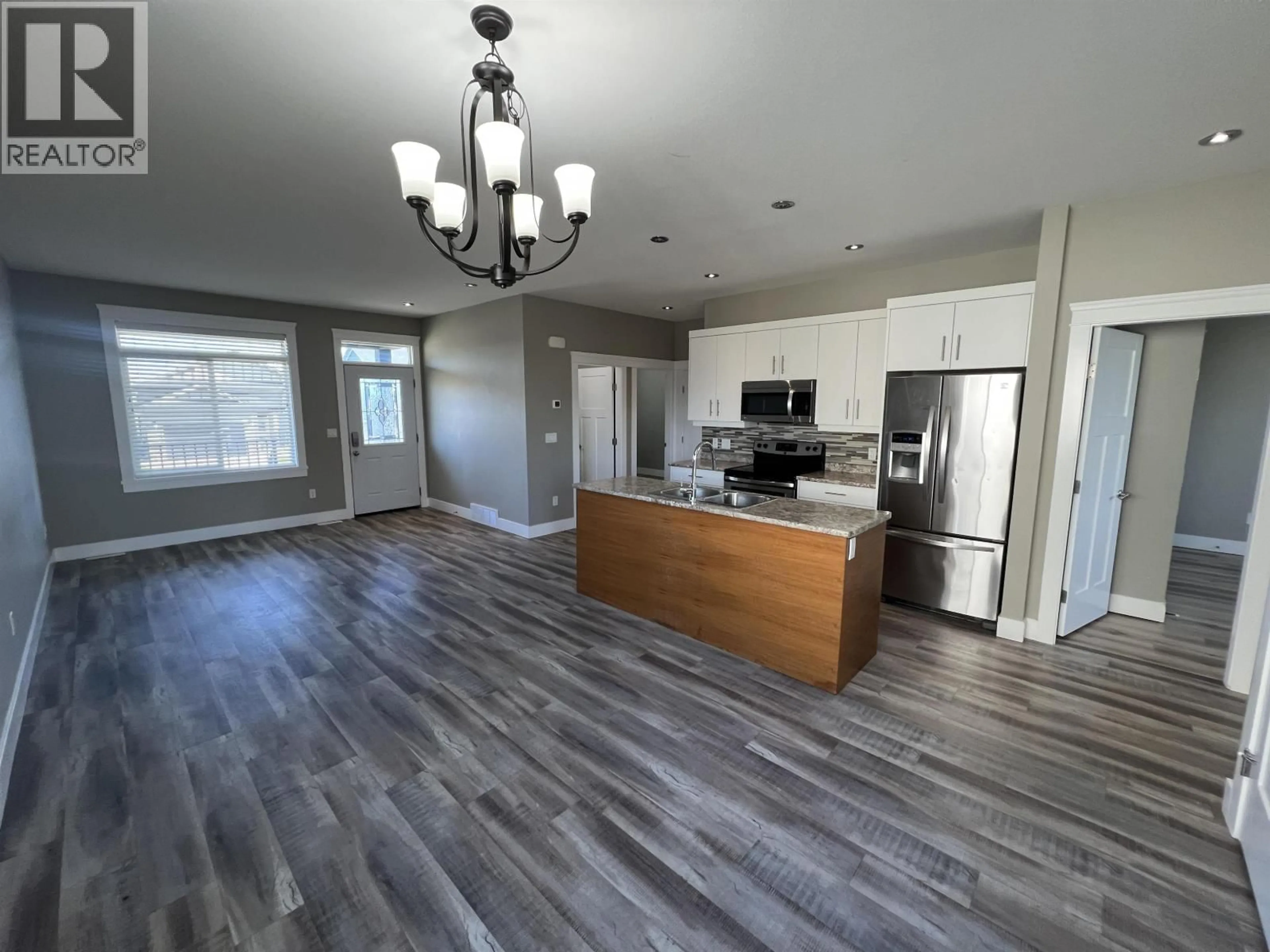 Open concept kitchen, wood/laminate floor for 8215 88 AVENUE, Fort St. John British Columbia V1J0N9