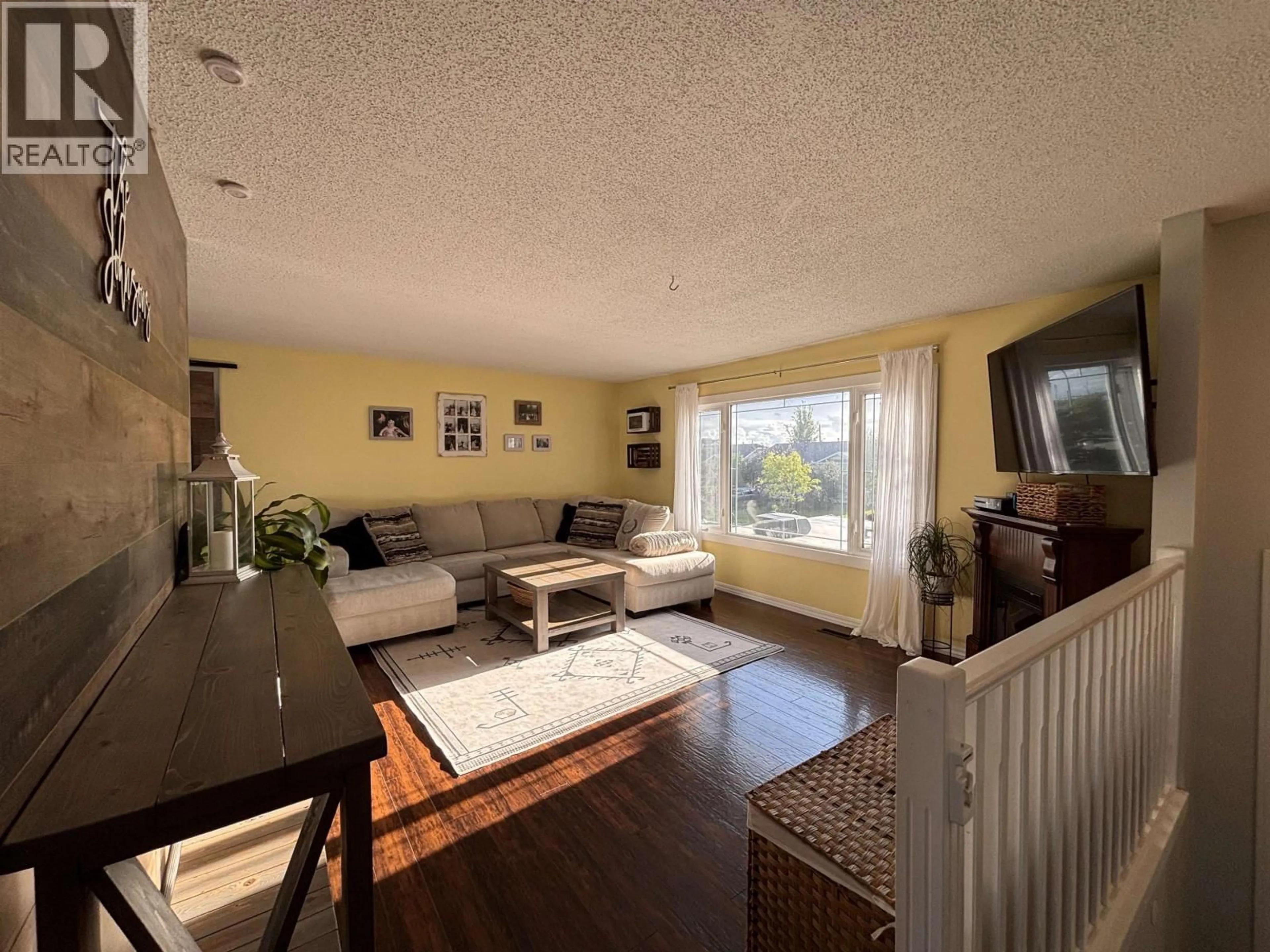 Living room with furniture, wood/laminate floor for 8611 90 STREET, Fort St. John British Columbia V1J4R5