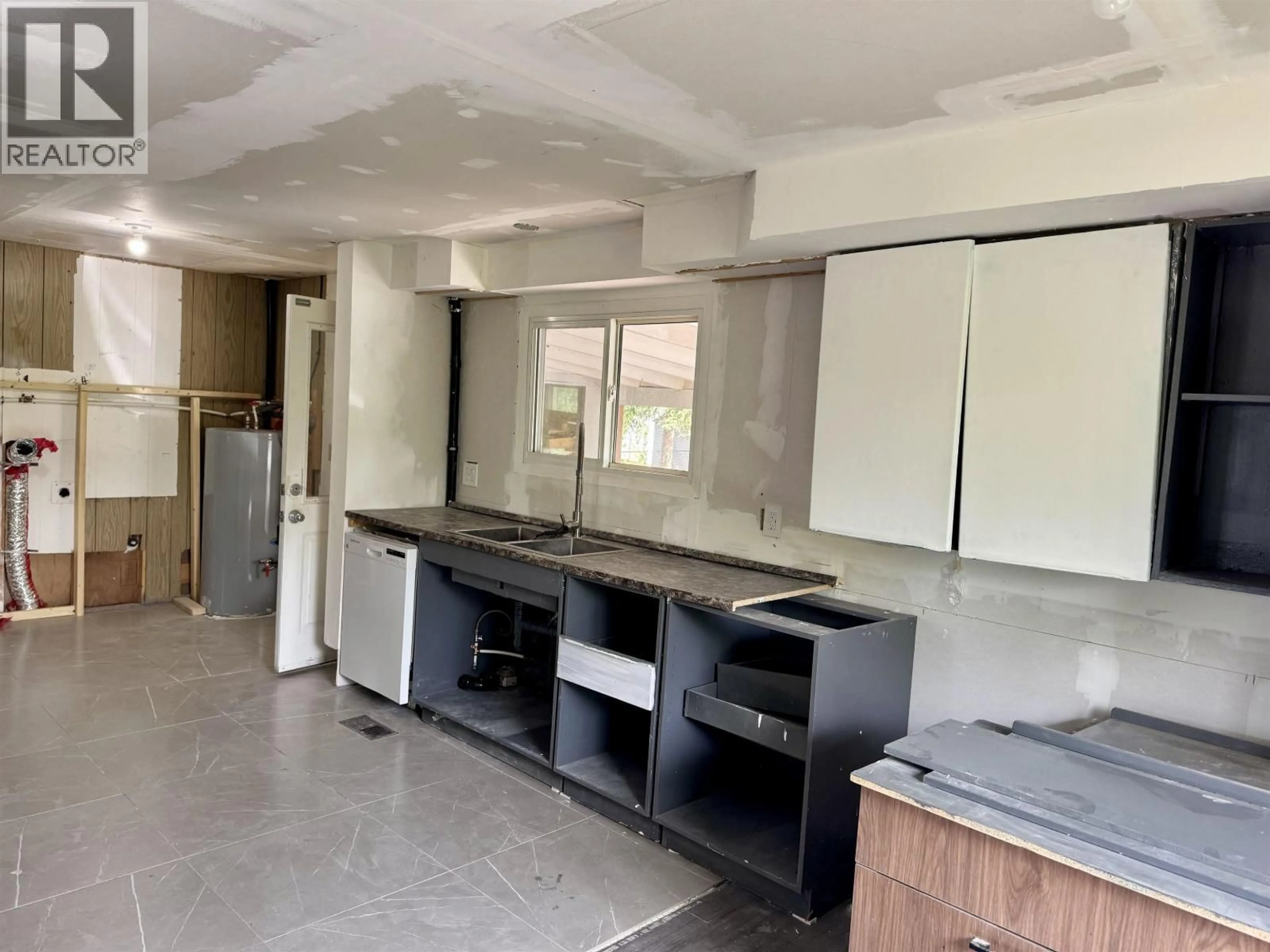 Kitchen with laundary machines, cement floor for 204 3RD AVENUE, Fort St. James British Columbia V0J1P0