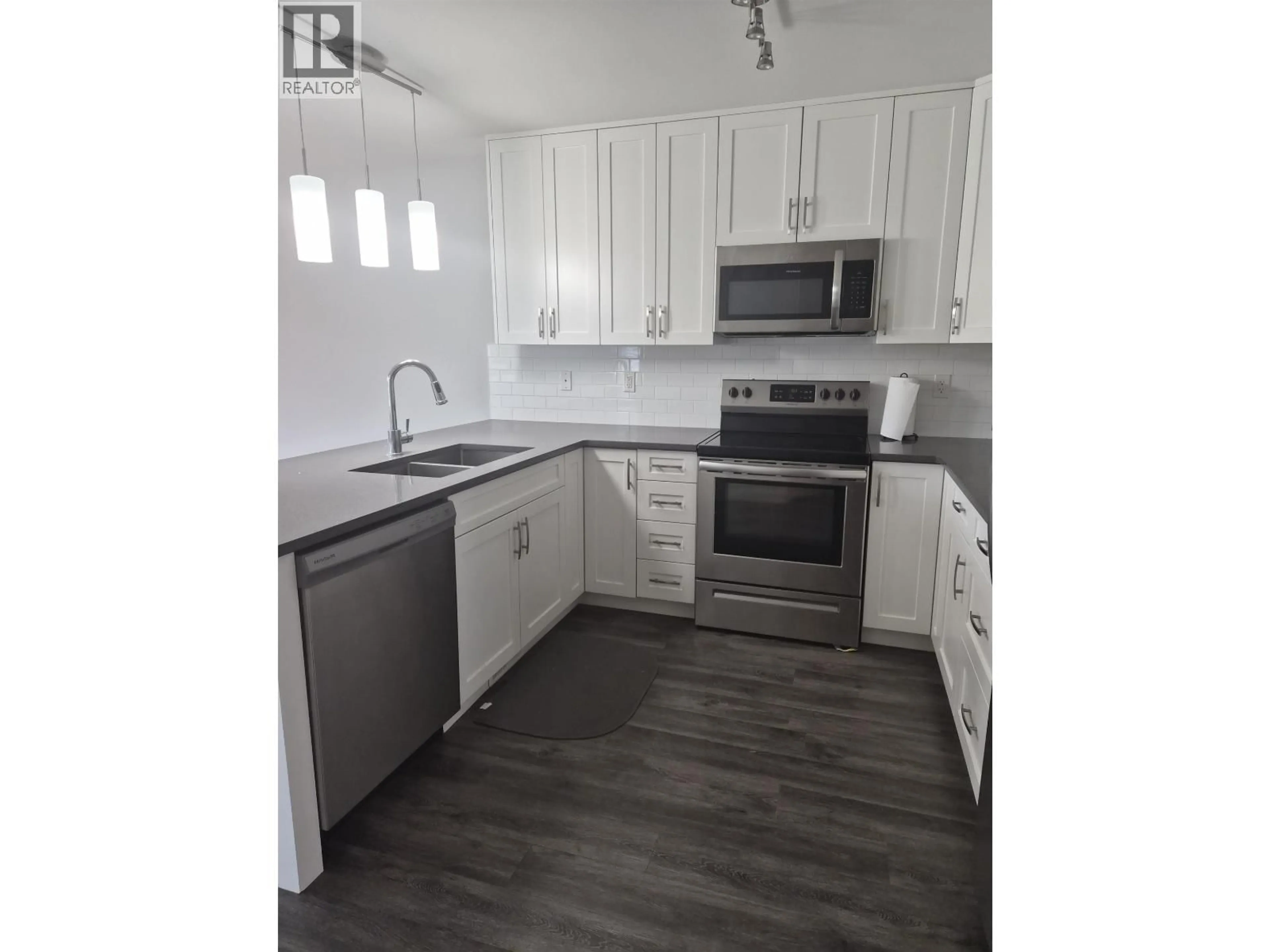 Open concept kitchen, wood/laminate floor for 401 - 6798 WESTGATE AVENUE, Prince George British Columbia V2N5R2