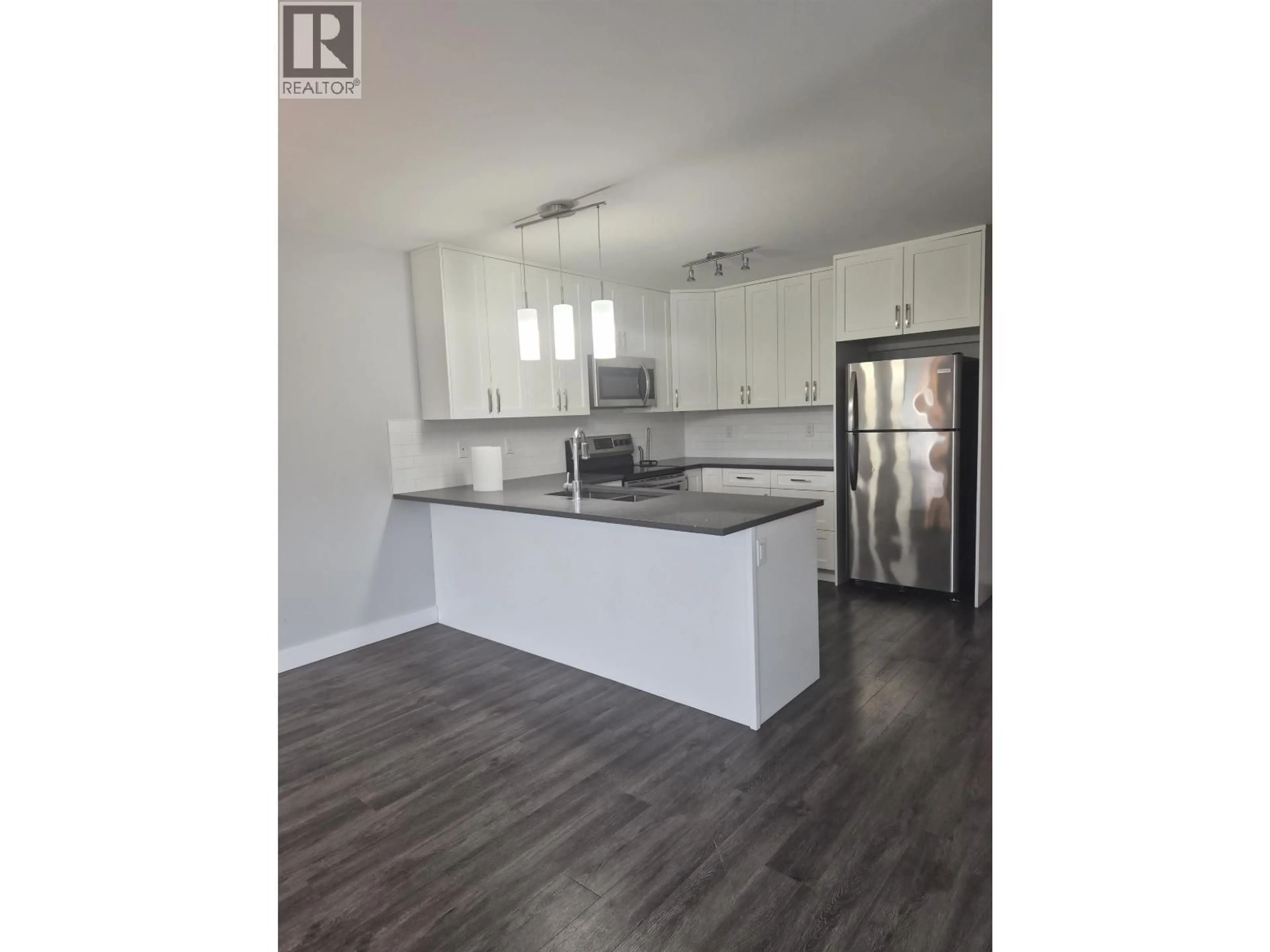 Open concept kitchen, wood/laminate floor for 401 - 6798 WESTGATE AVENUE, Prince George British Columbia V2N5R2