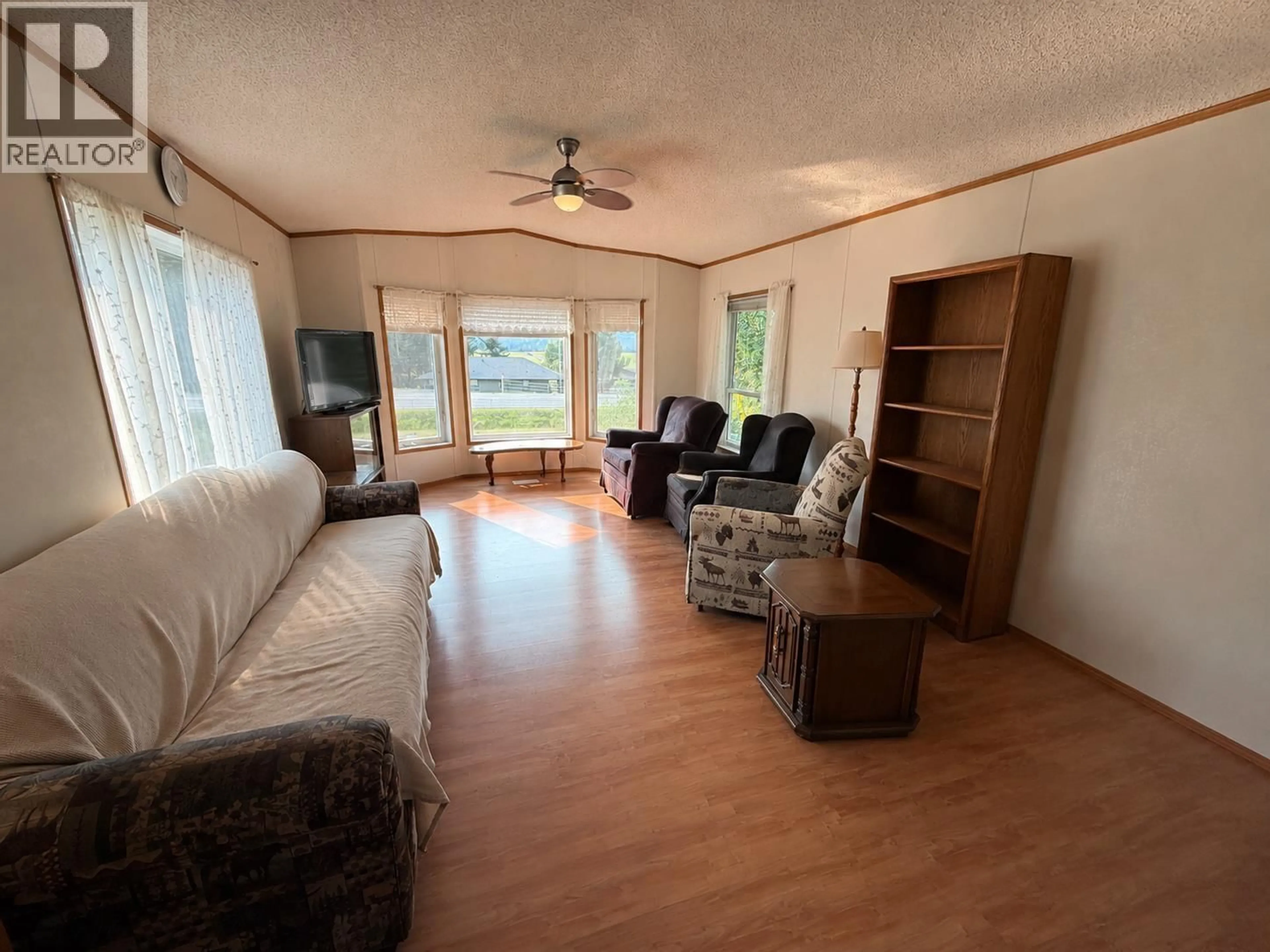 Living room with furniture, wood/laminate floor for 4580 CANIM HENDRIX ROAD, 100 Mile House British Columbia V0K1M0
