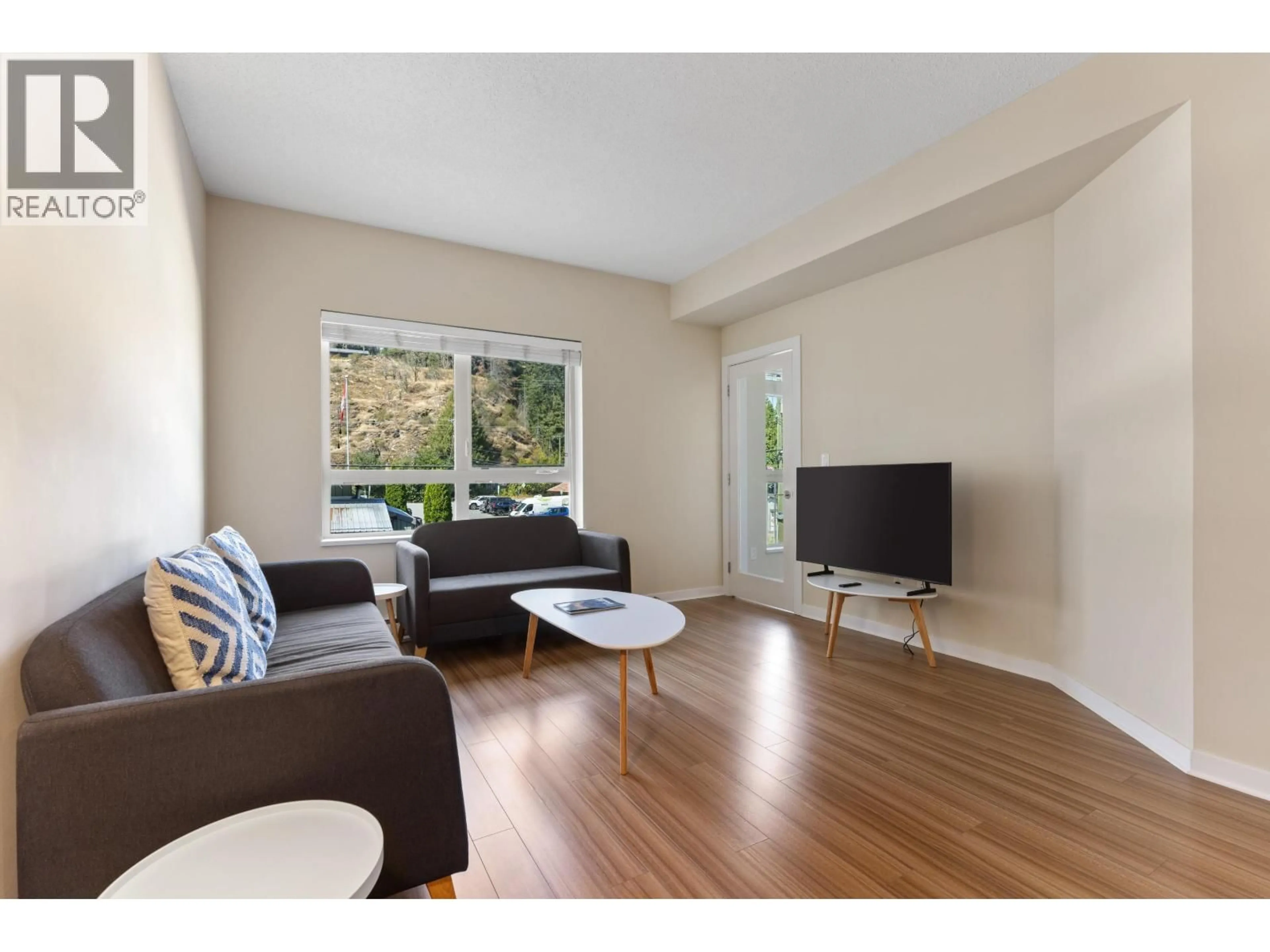 Living room with furniture, wood/laminate floor for 202 - 7445 FRONTIER STREET, Pemberton British Columbia V0N2L1