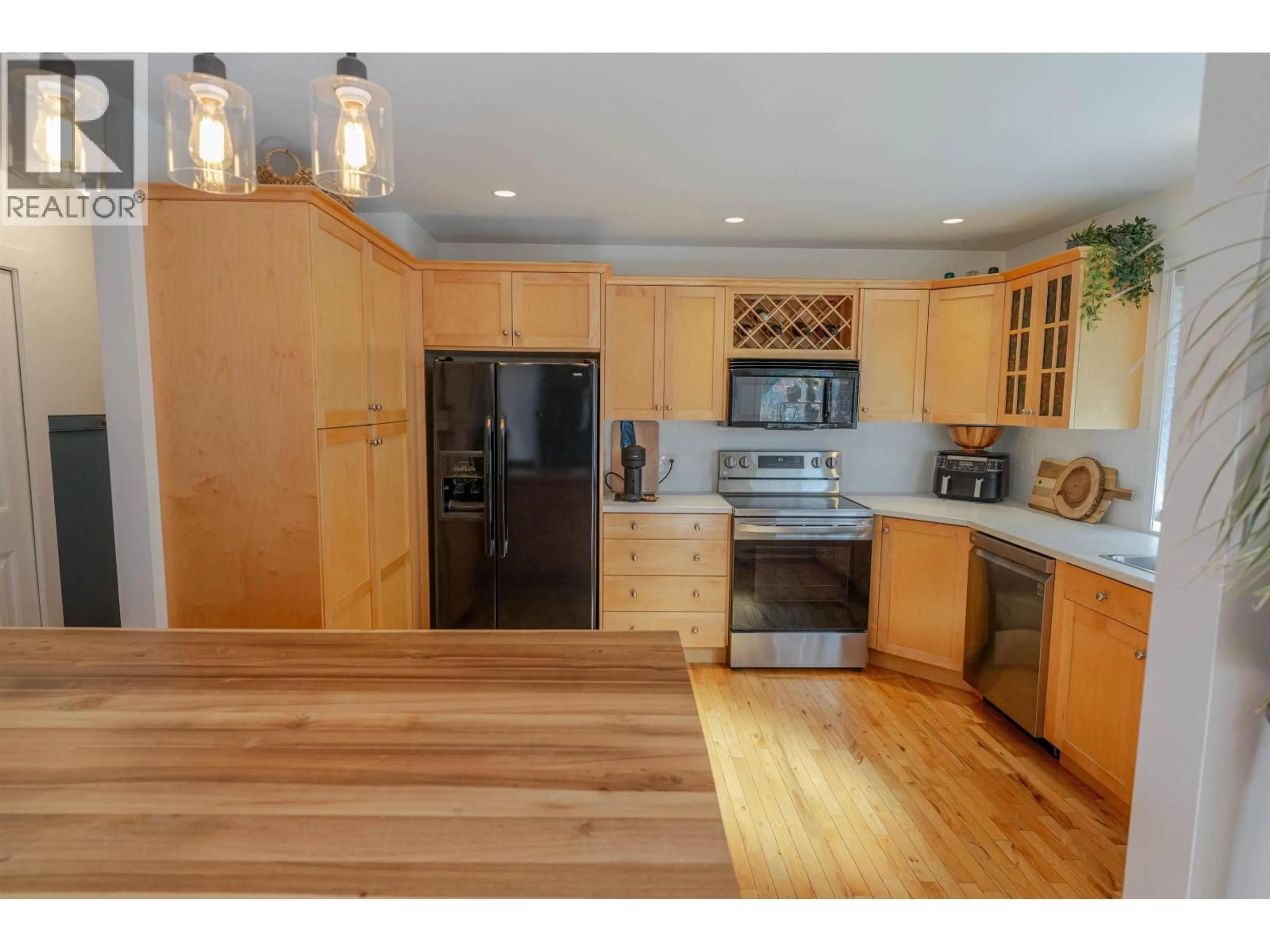Open concept kitchen, wood/laminate floor for 10707 108 STREET, Fort St. John British Columbia V1J5N9