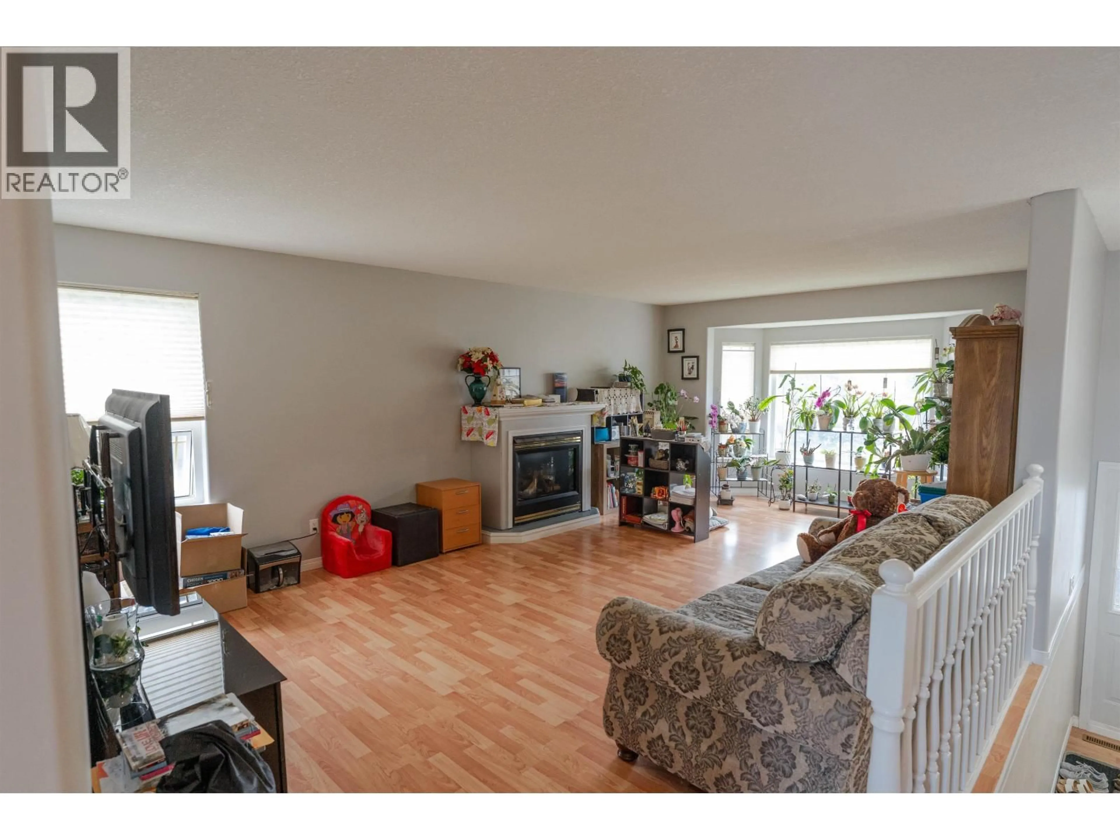 Living room with furniture, wood/laminate floor for 8720 117 AVENUE, Fort St. John British Columbia V1J6W6