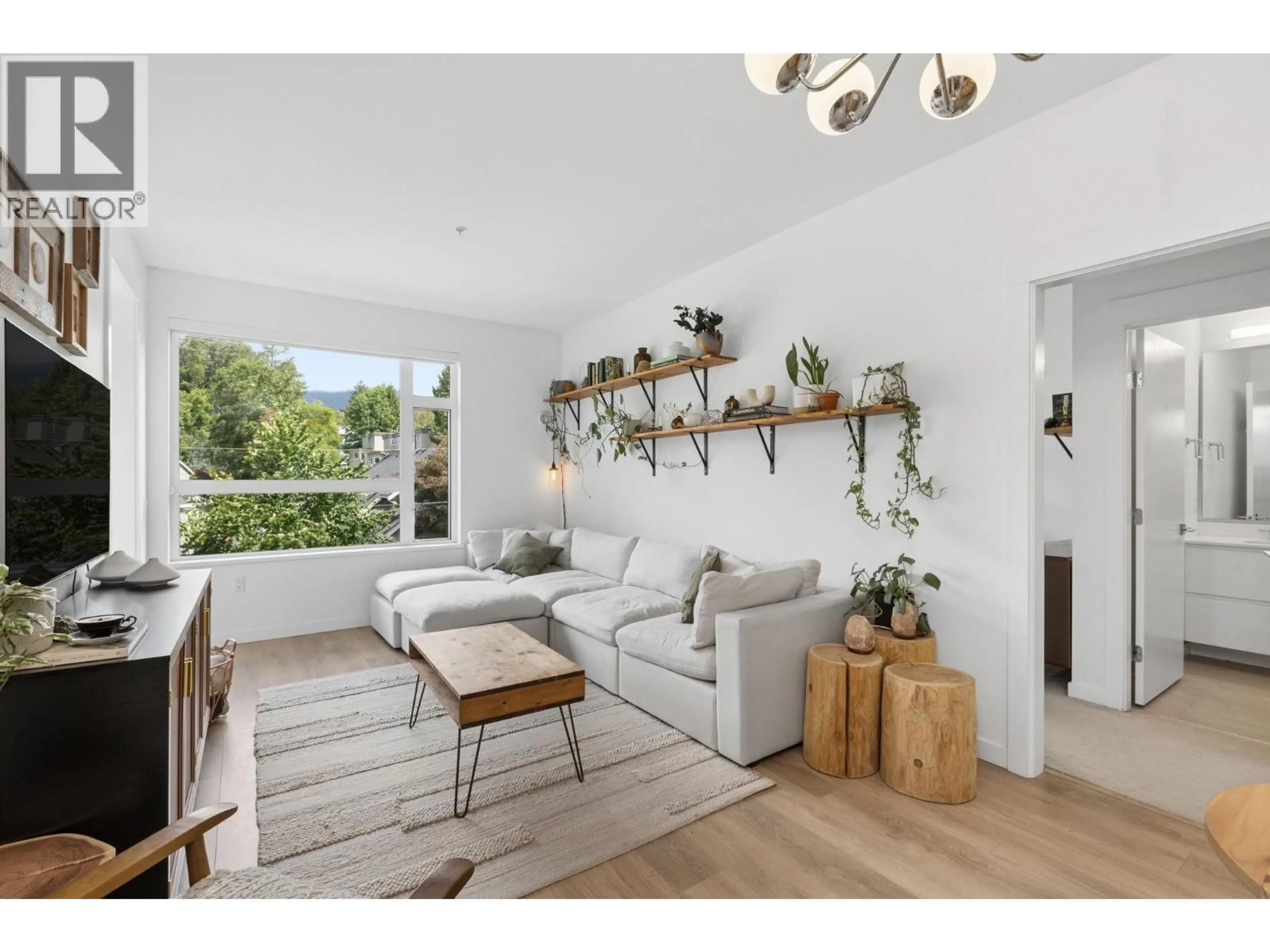 Living room with furniture, wood/laminate floor for 209 - 715 15TH STREET, North Vancouver British Columbia V7M1T2