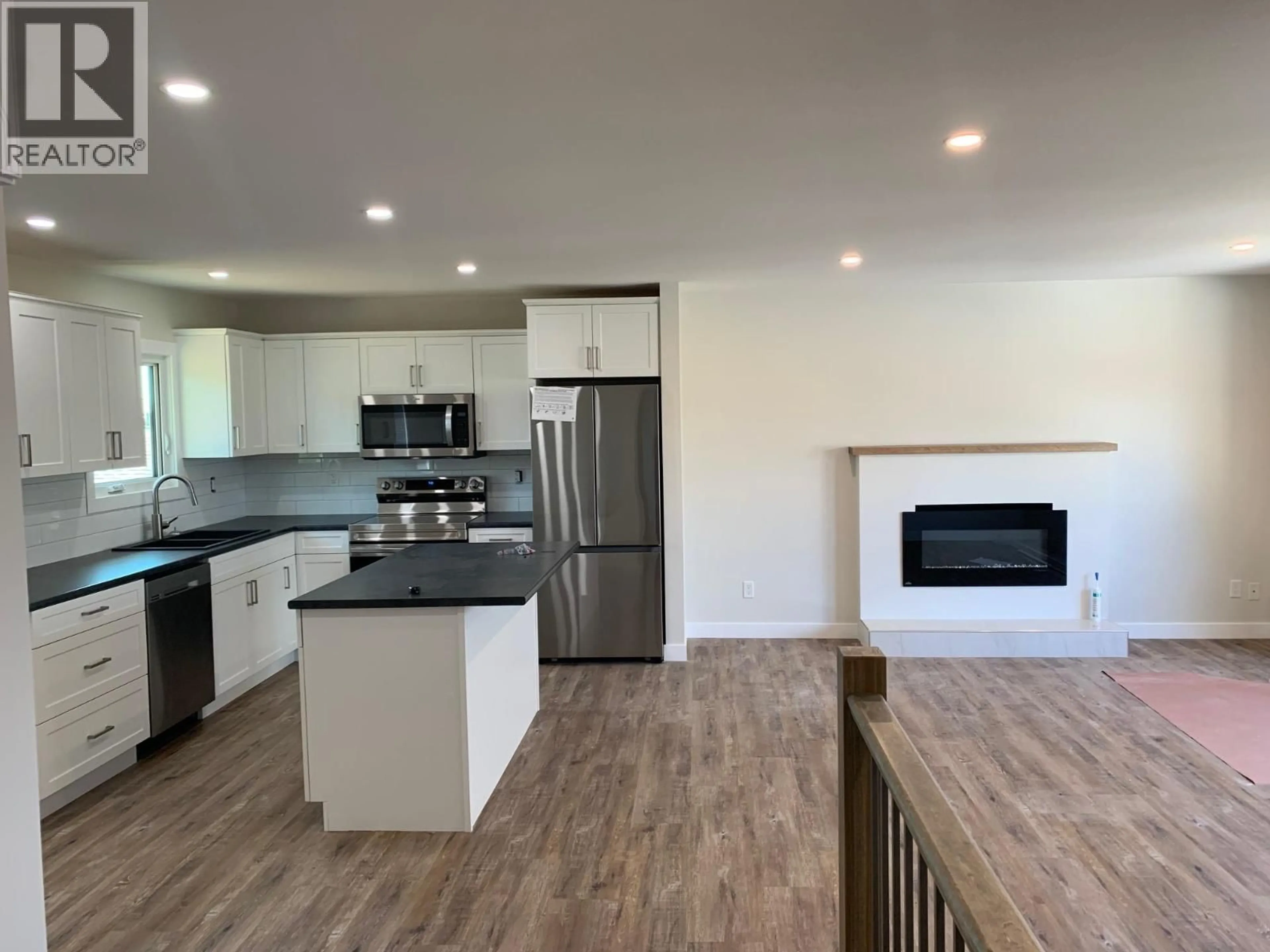 Open concept kitchen, wood/laminate floor for 9119 89 STREET, Fort St. John British Columbia V1J4Z3