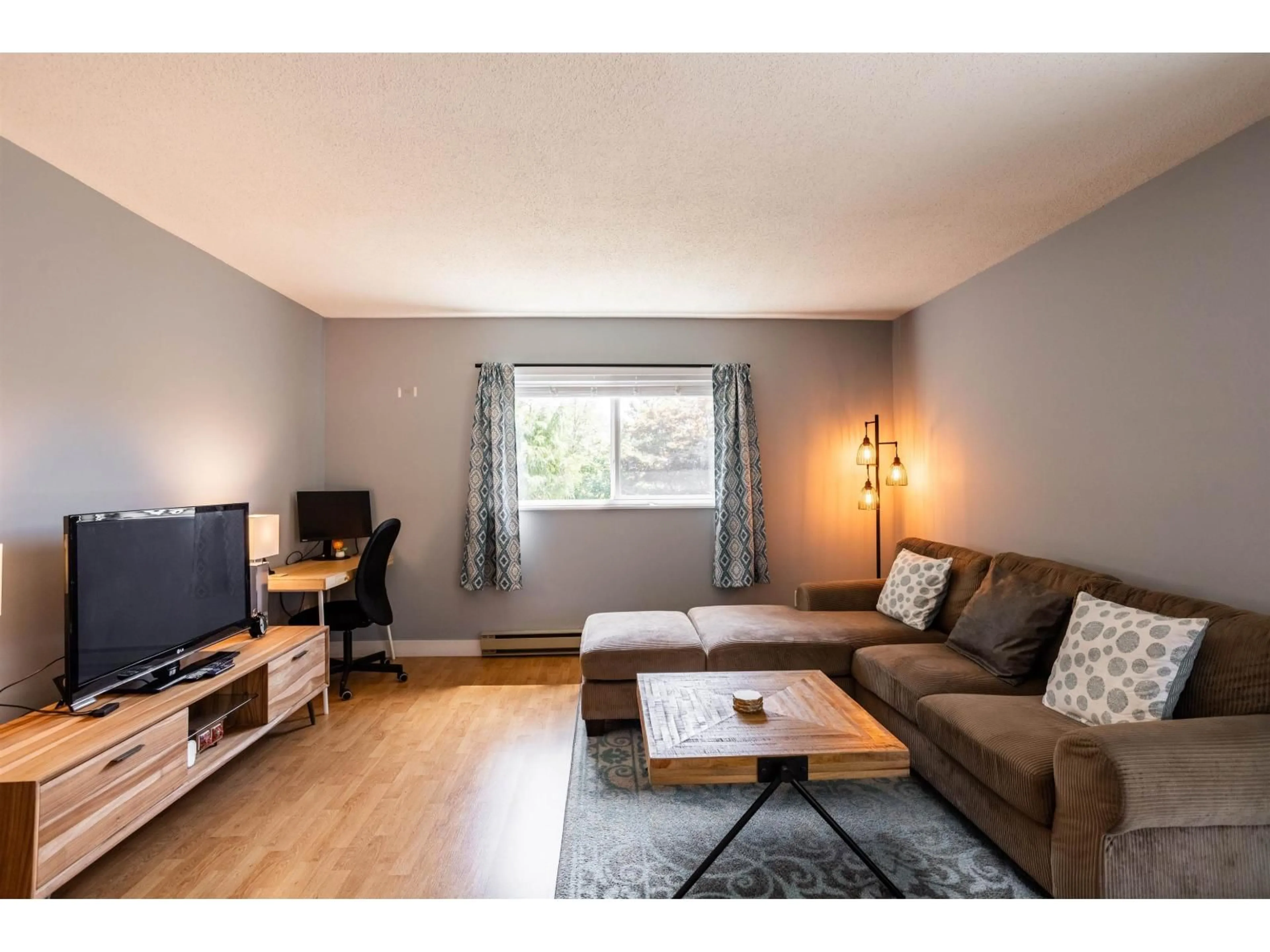 Living room with furniture, wood/laminate floor for 210 - 5191 203 STREET, Langley British Columbia V3A1V6