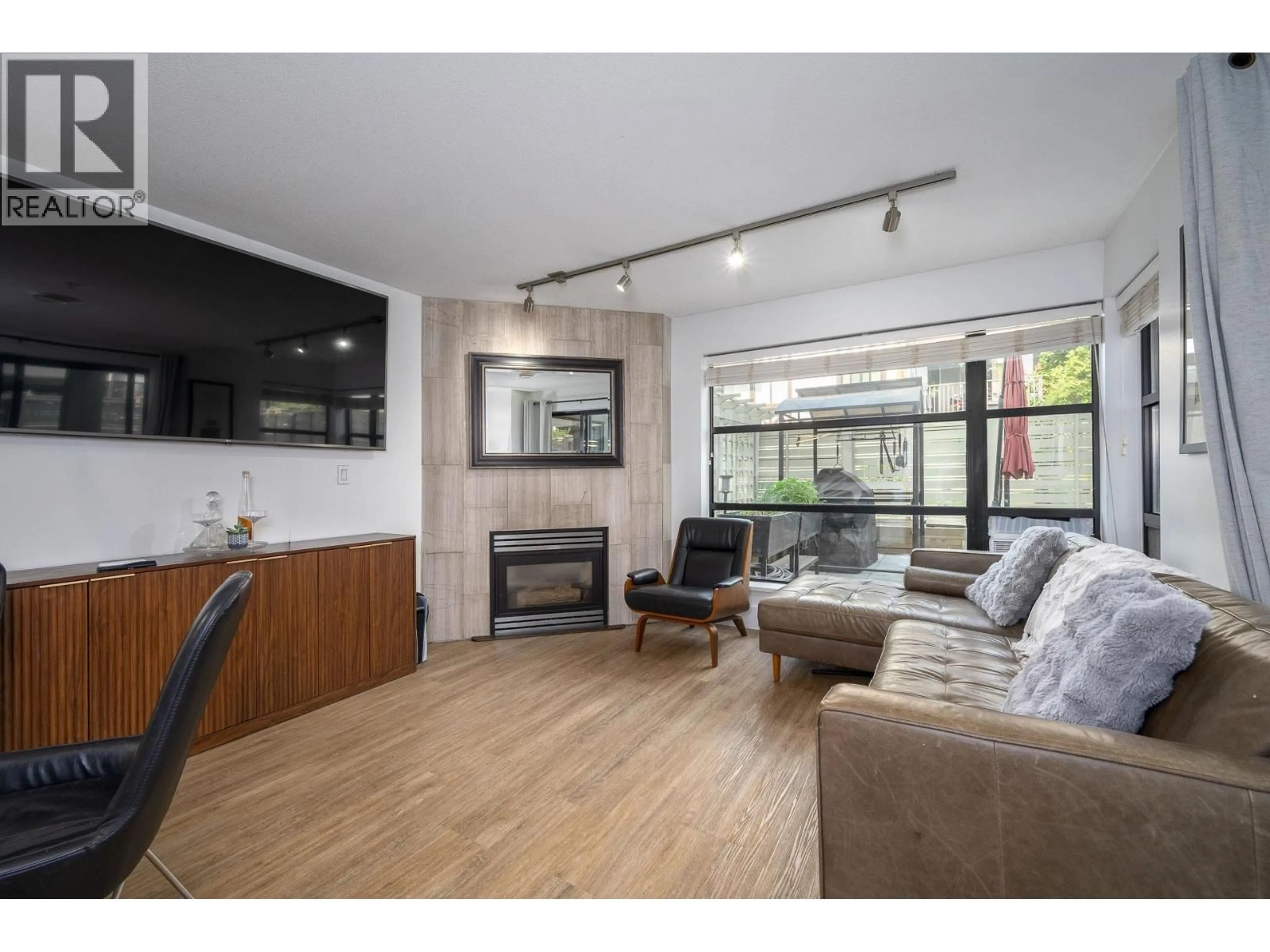 Living room with furniture, wood/laminate floor for 204 - 124 3RD STREET, North Vancouver British Columbia V7M1E8