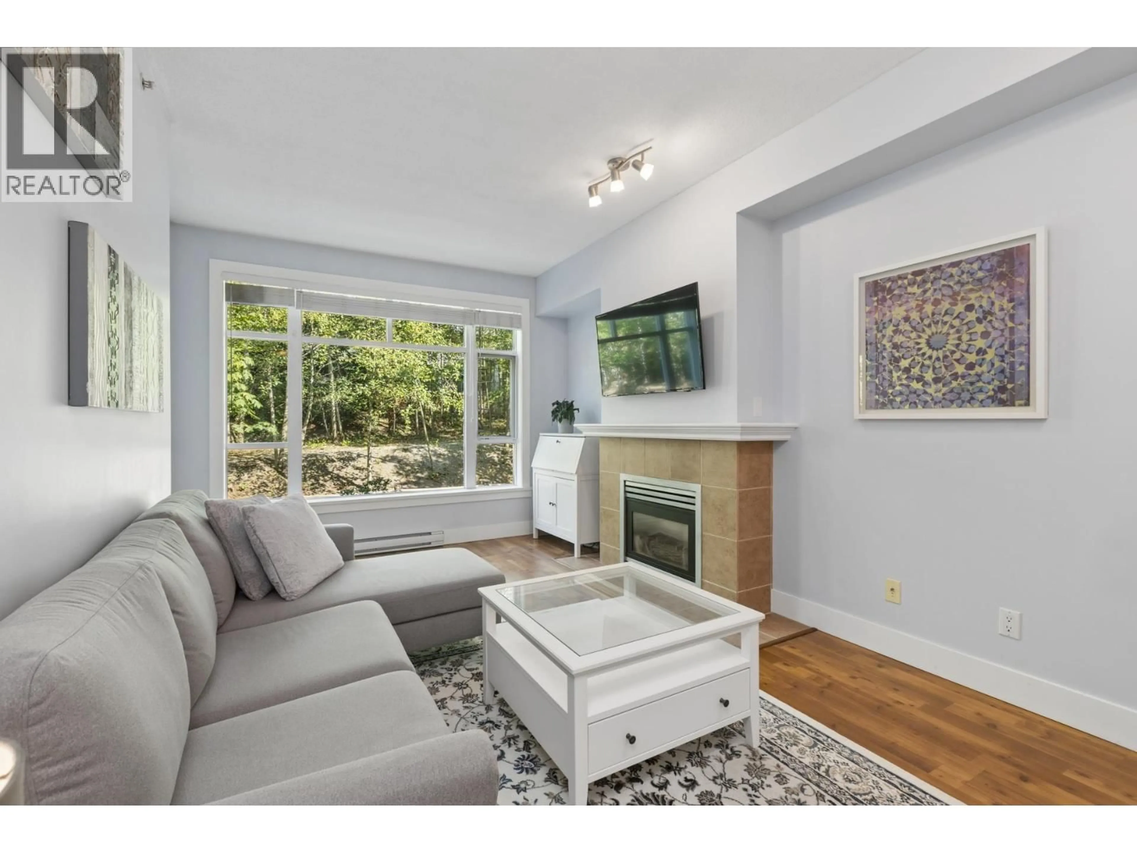 Living room with furniture, wood/laminate floor for 321 - 3600 WINDCREST DRIVE, North Vancouver British Columbia V7G2S5