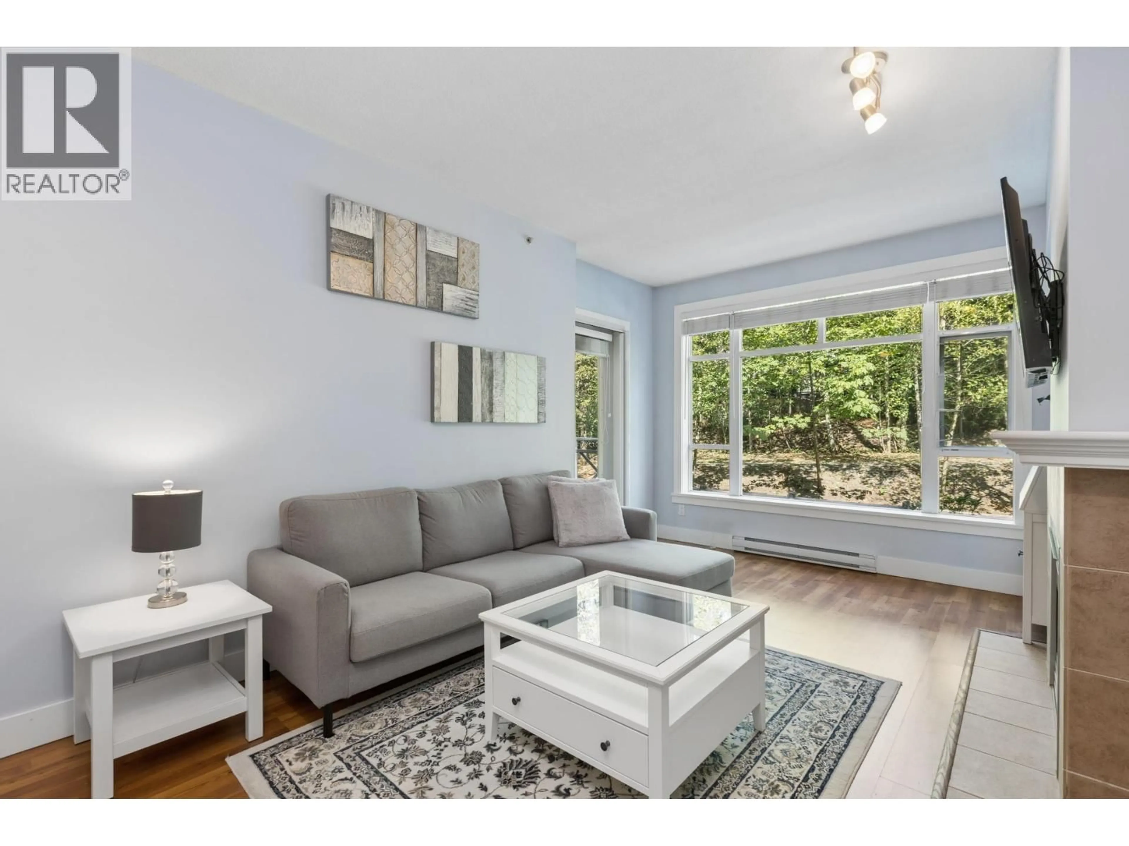 Living room with furniture, wood/laminate floor for 321 - 3600 WINDCREST DRIVE, North Vancouver British Columbia V7G2S5