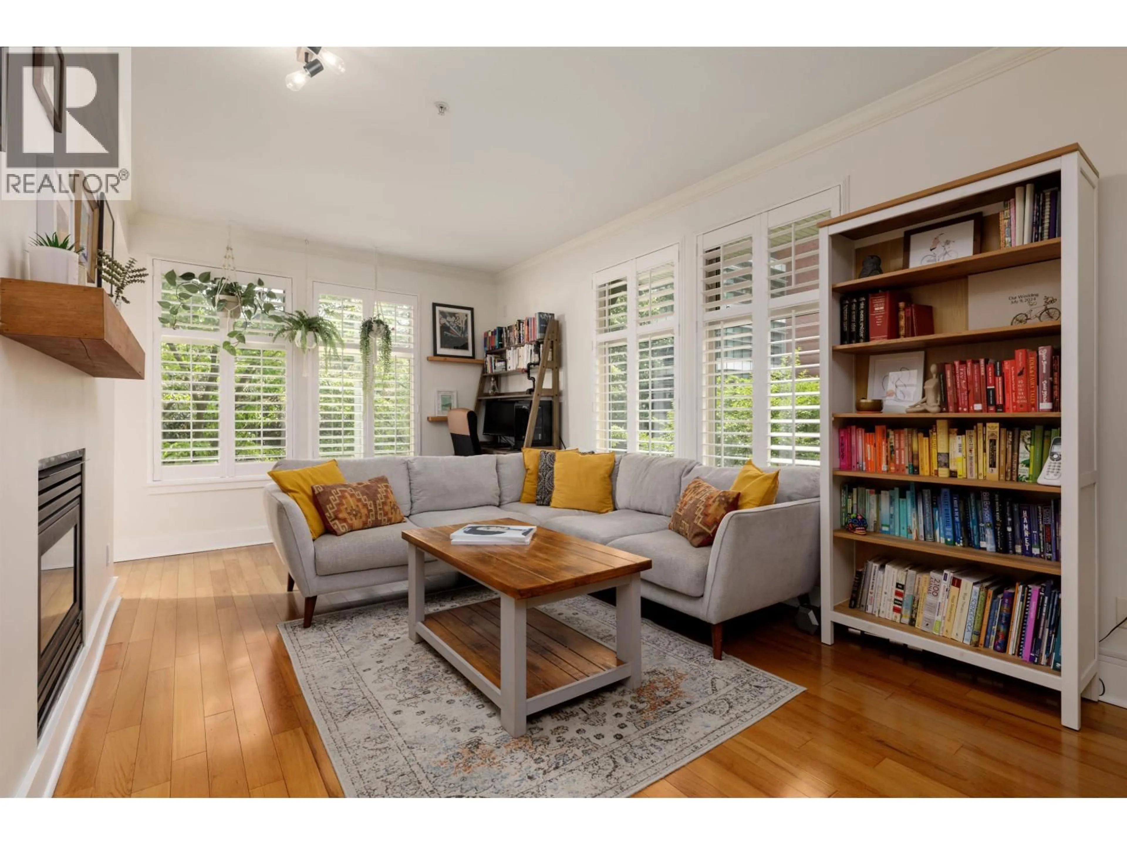 Living room with furniture, wood/laminate floor for 201 - 118 22ND STREET, North Vancouver British Columbia V7M1Z9