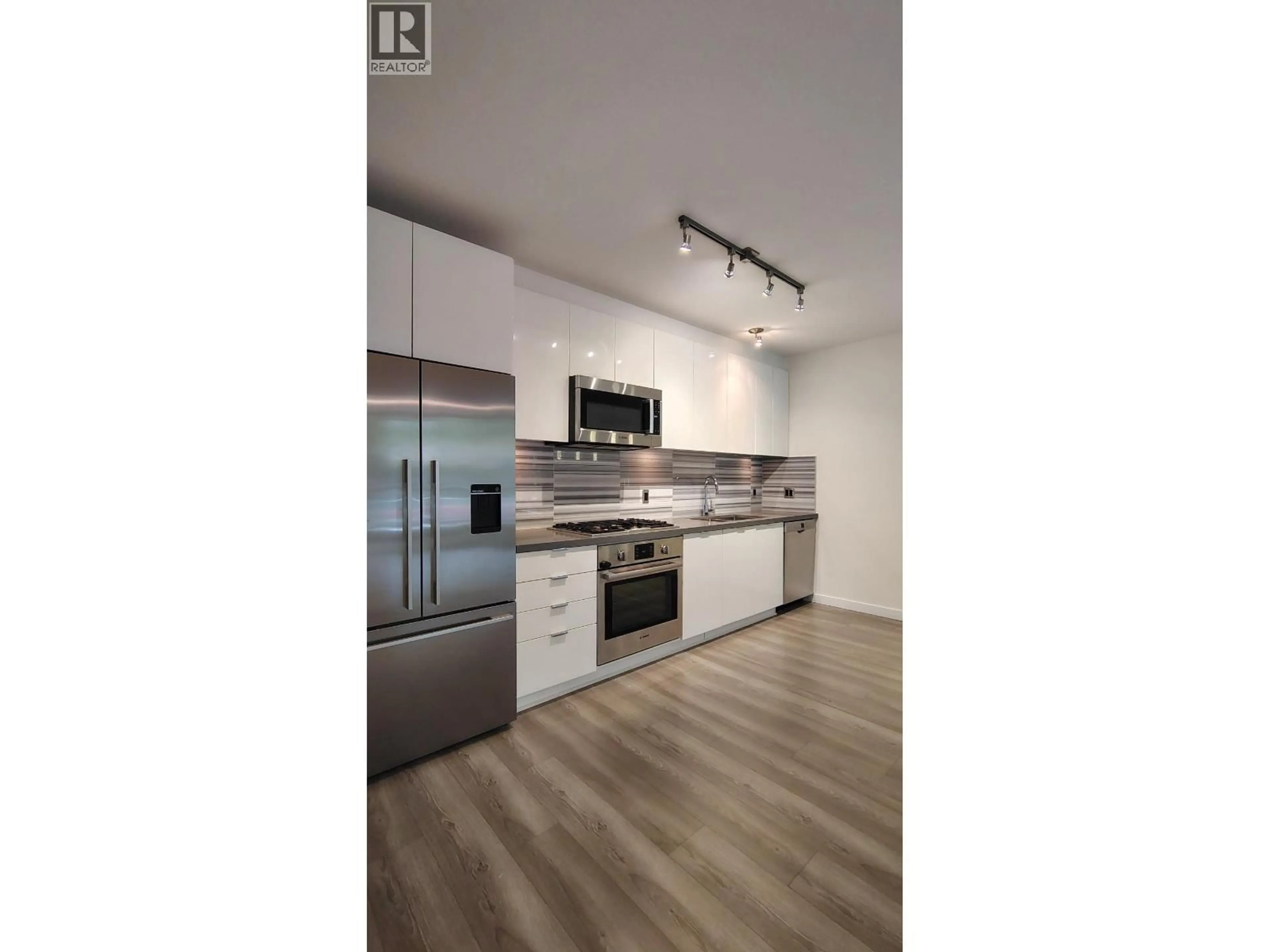 Open concept kitchen, wood/laminate floor for 101 - 3168 RIVERWALK AVENUE, Vancouver British Columbia V5S0B8