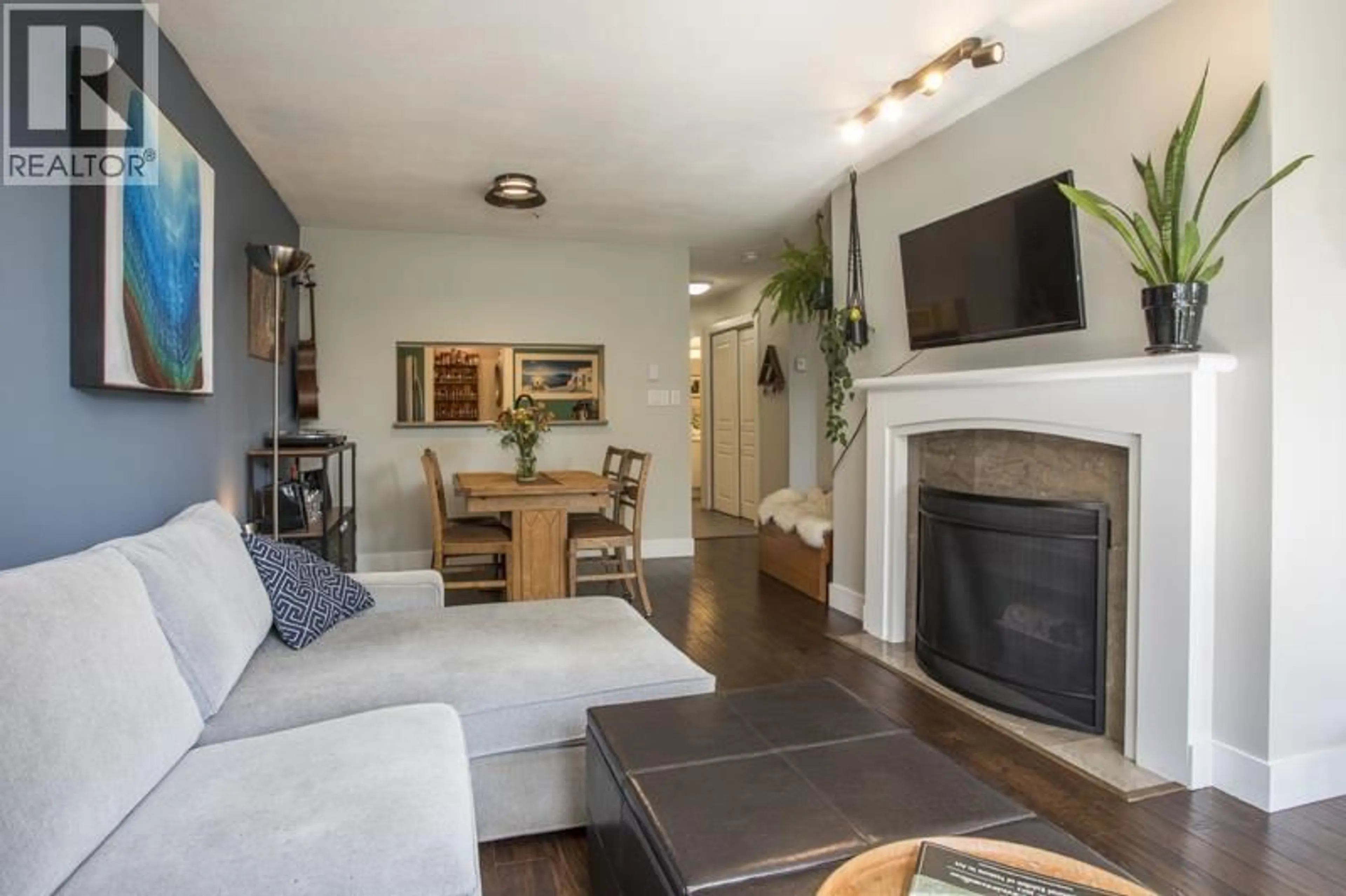 Living room with furniture, wood/laminate floor for 211 - 8460 JELLICOE STREET, Vancouver British Columbia V5S4S8