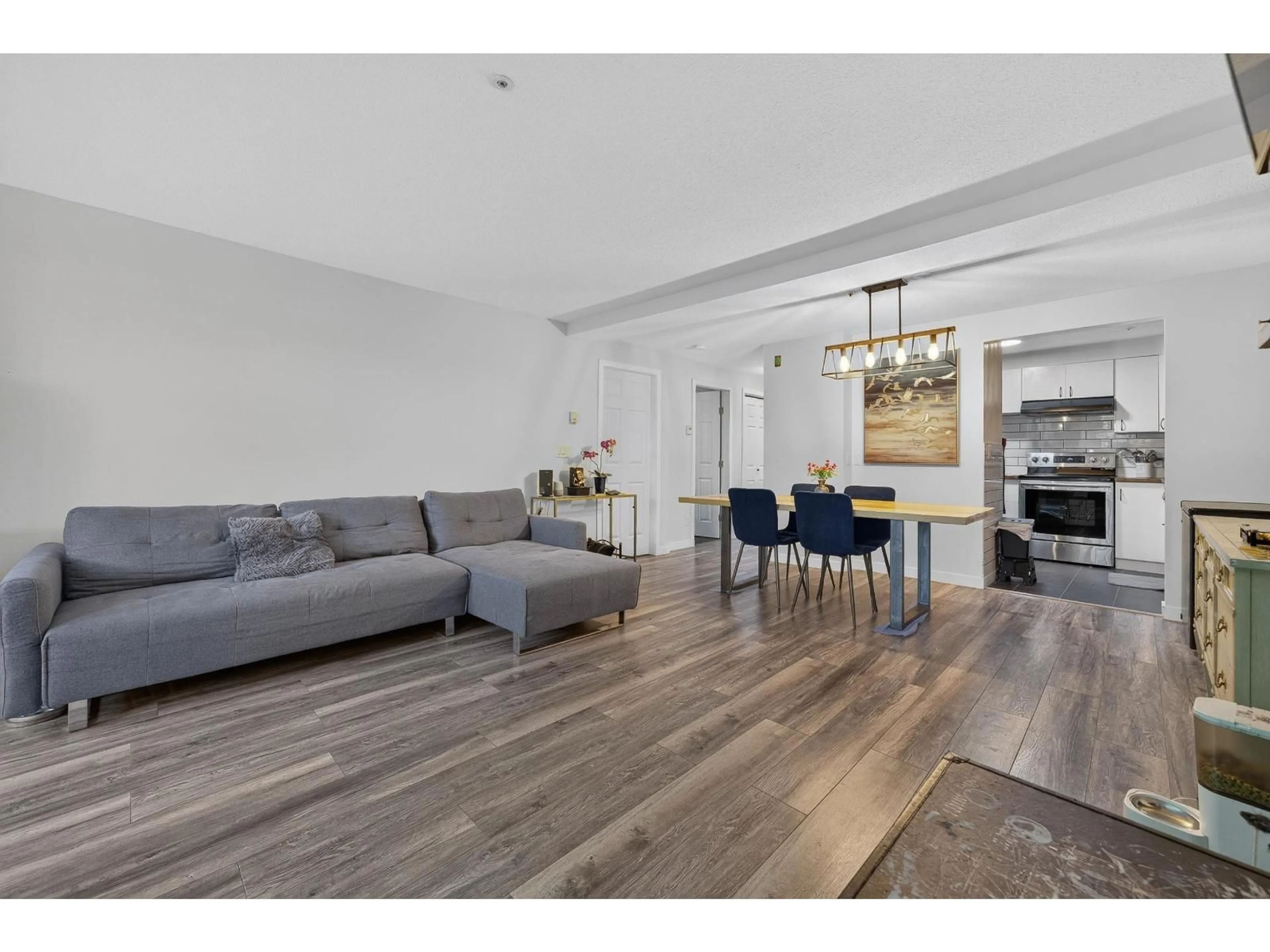 Living room with furniture, wood/laminate floor for 104 - 7475 138 STREET, Surrey British Columbia V3W0Y9