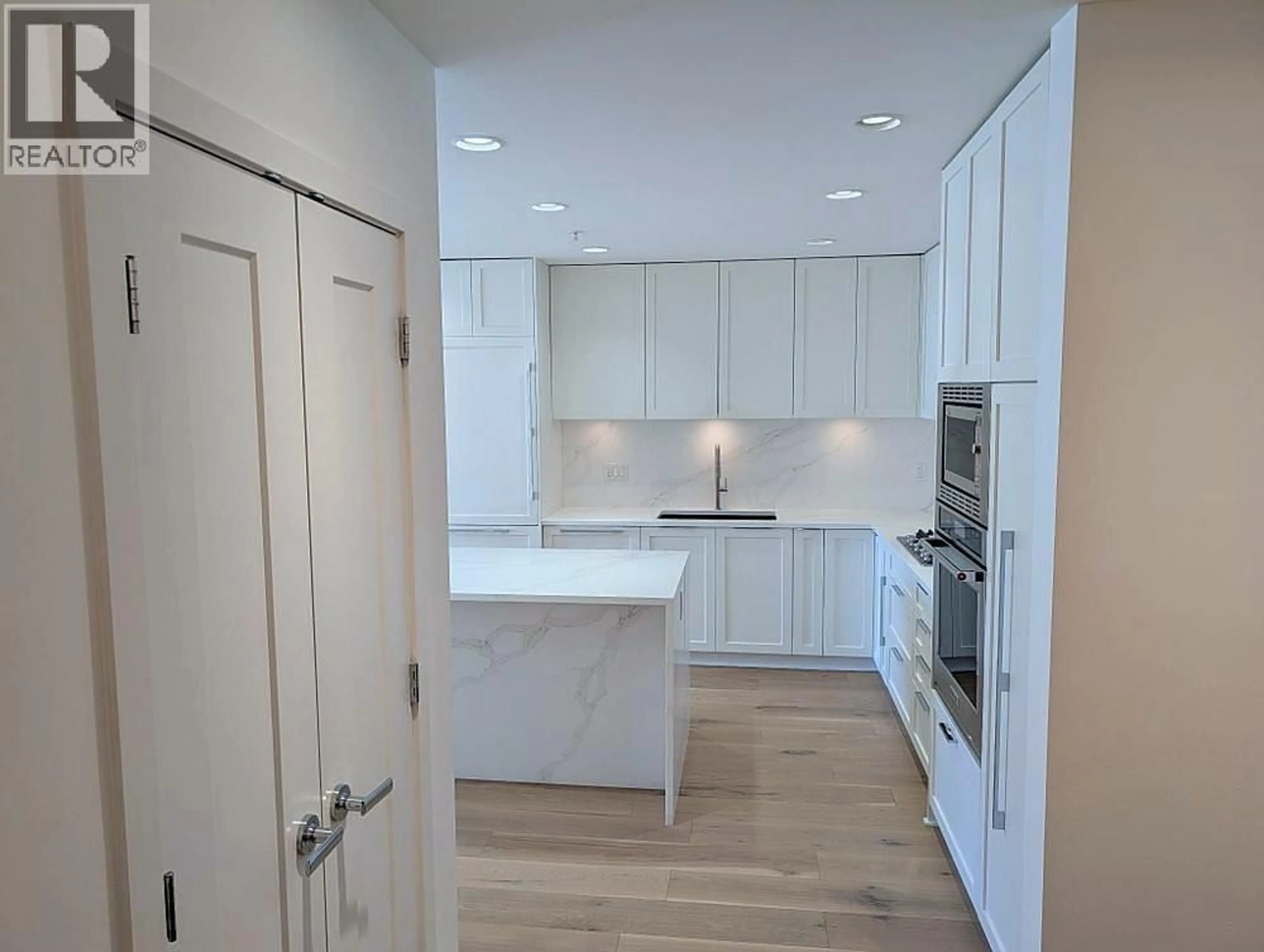 Open concept kitchen, wood/laminate floor for 102 - 3873 CATES LANDING WAY, North Vancouver British Columbia V7G0A6