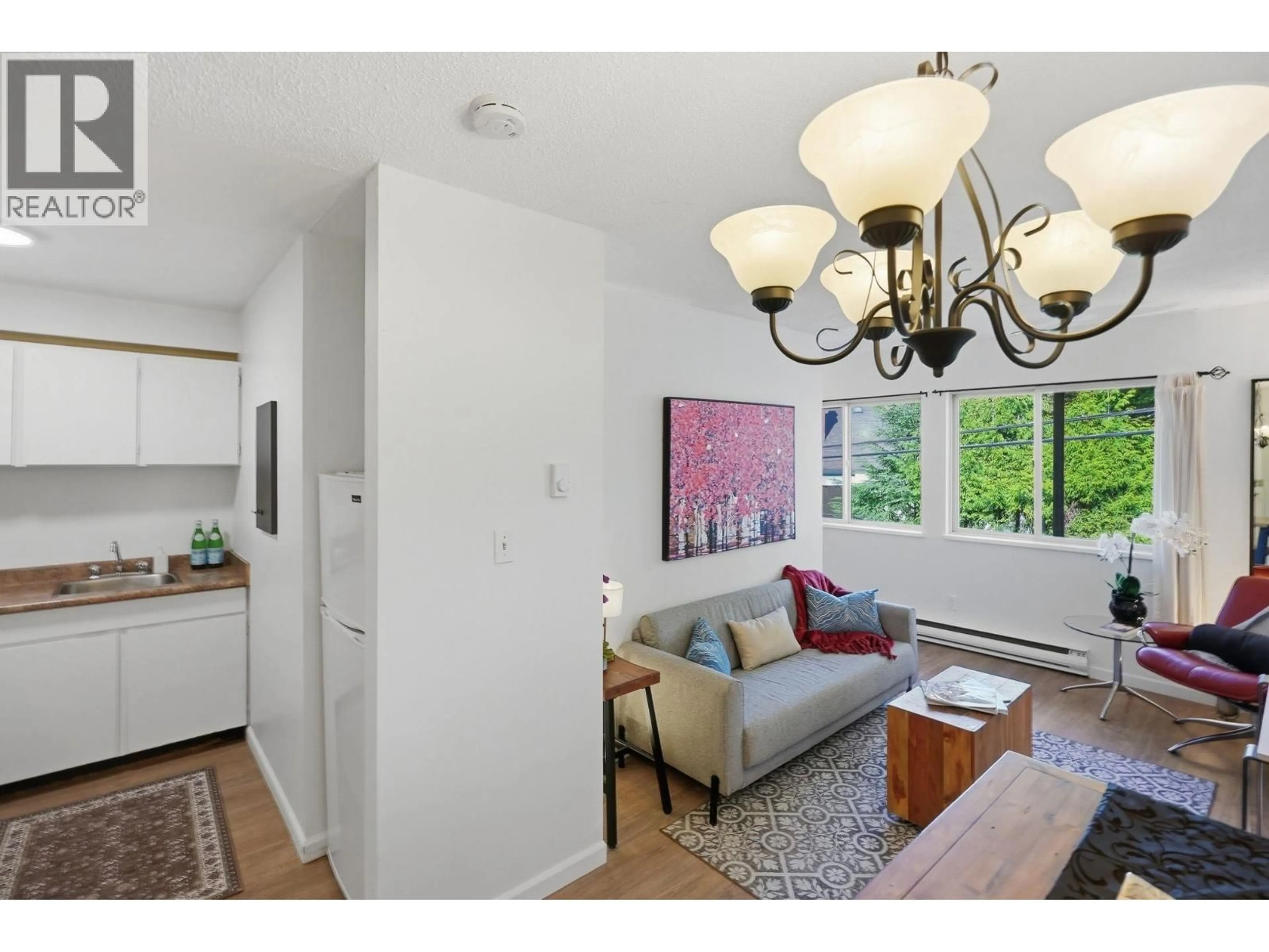 Living room with furniture, wood/laminate floor for 104 - 3465 GLEN DRIVE, Vancouver British Columbia V5V4S5