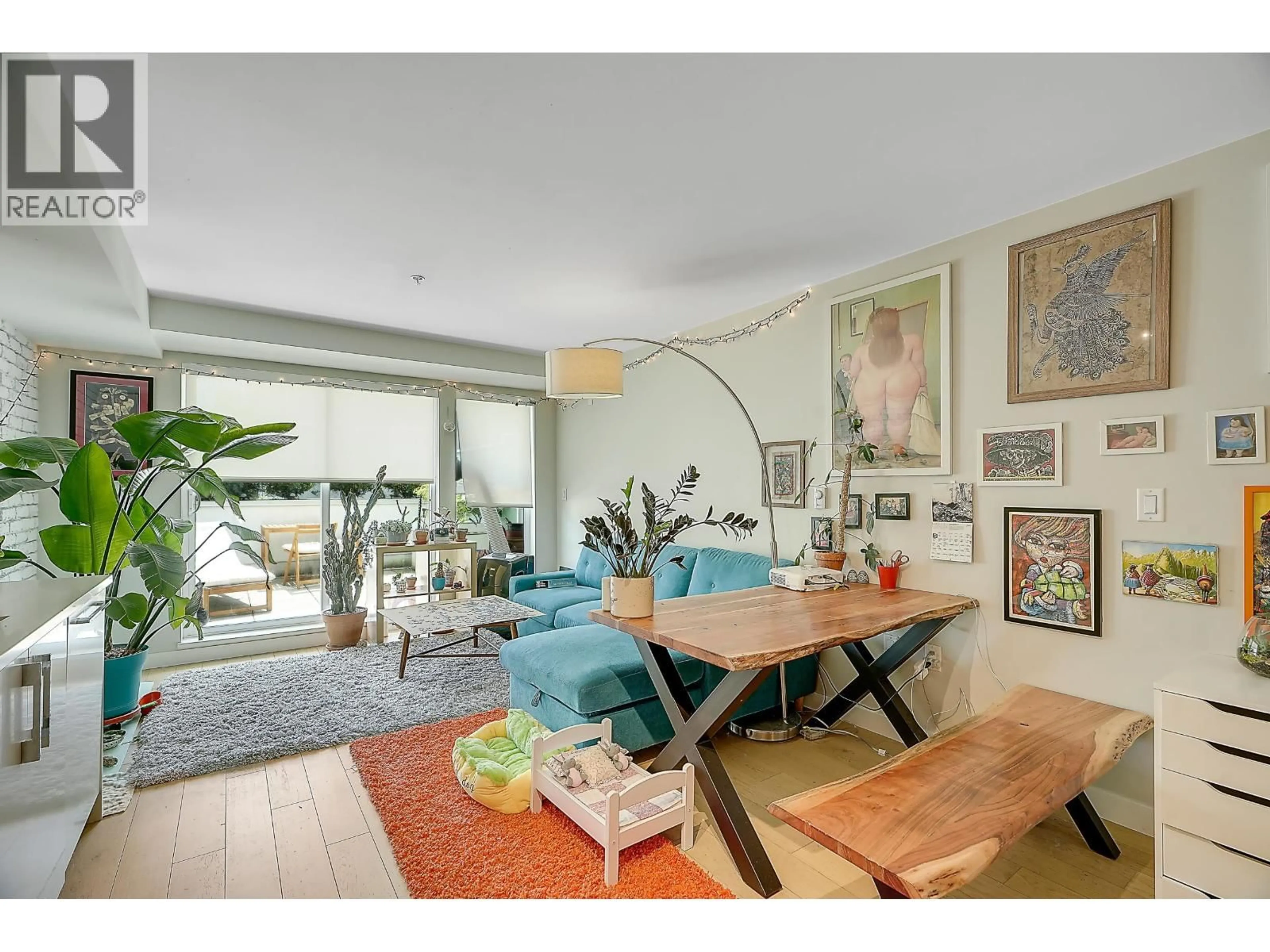 Living room with furniture, wood/laminate floor for 210 - 2508 FRASER STREET, Vancouver British Columbia V5T3V4