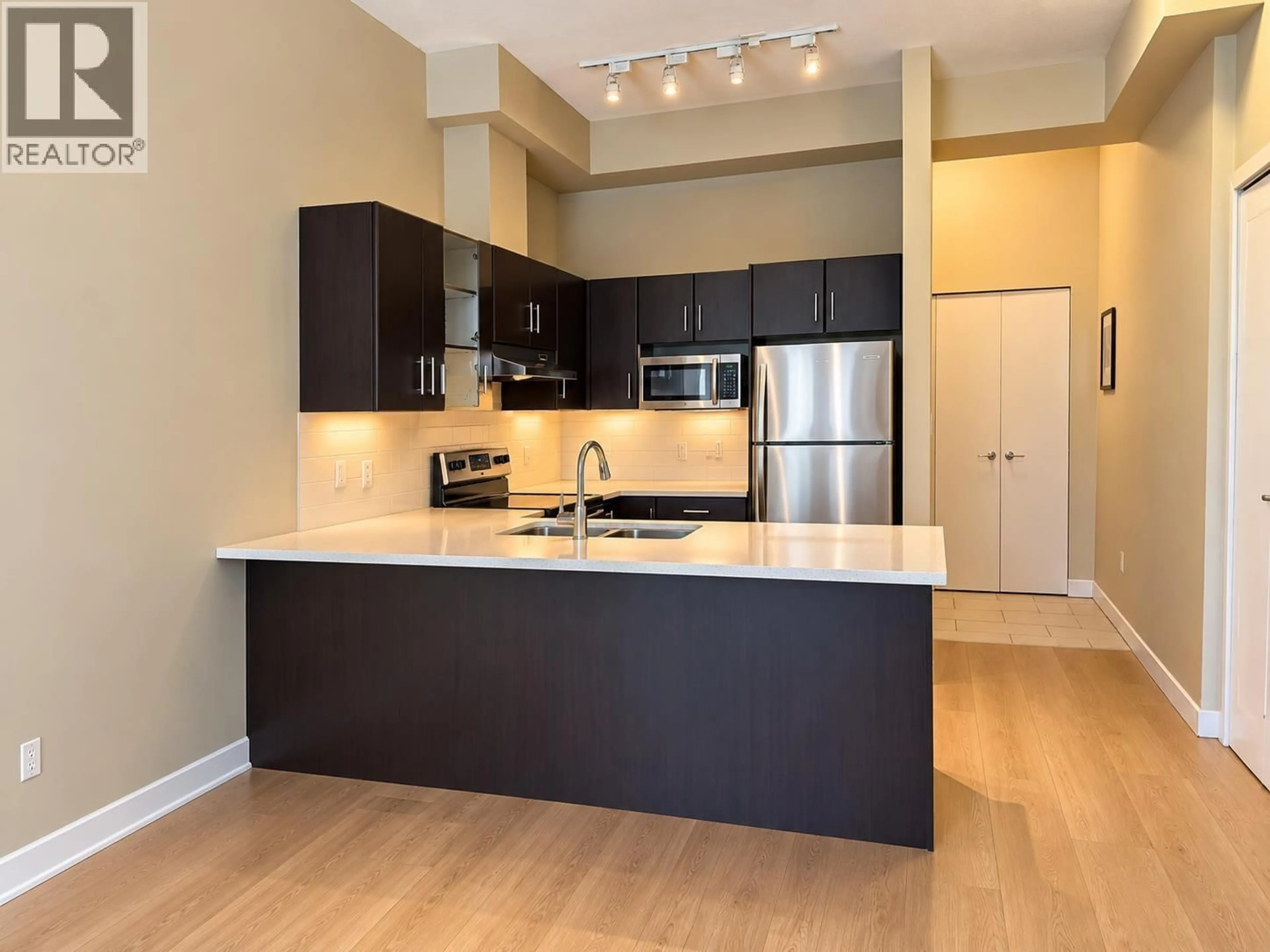 Open concept kitchen, wood/laminate floor for 107 - 41105 TANTALUS ROAD, Squamish British Columbia V8B0N3