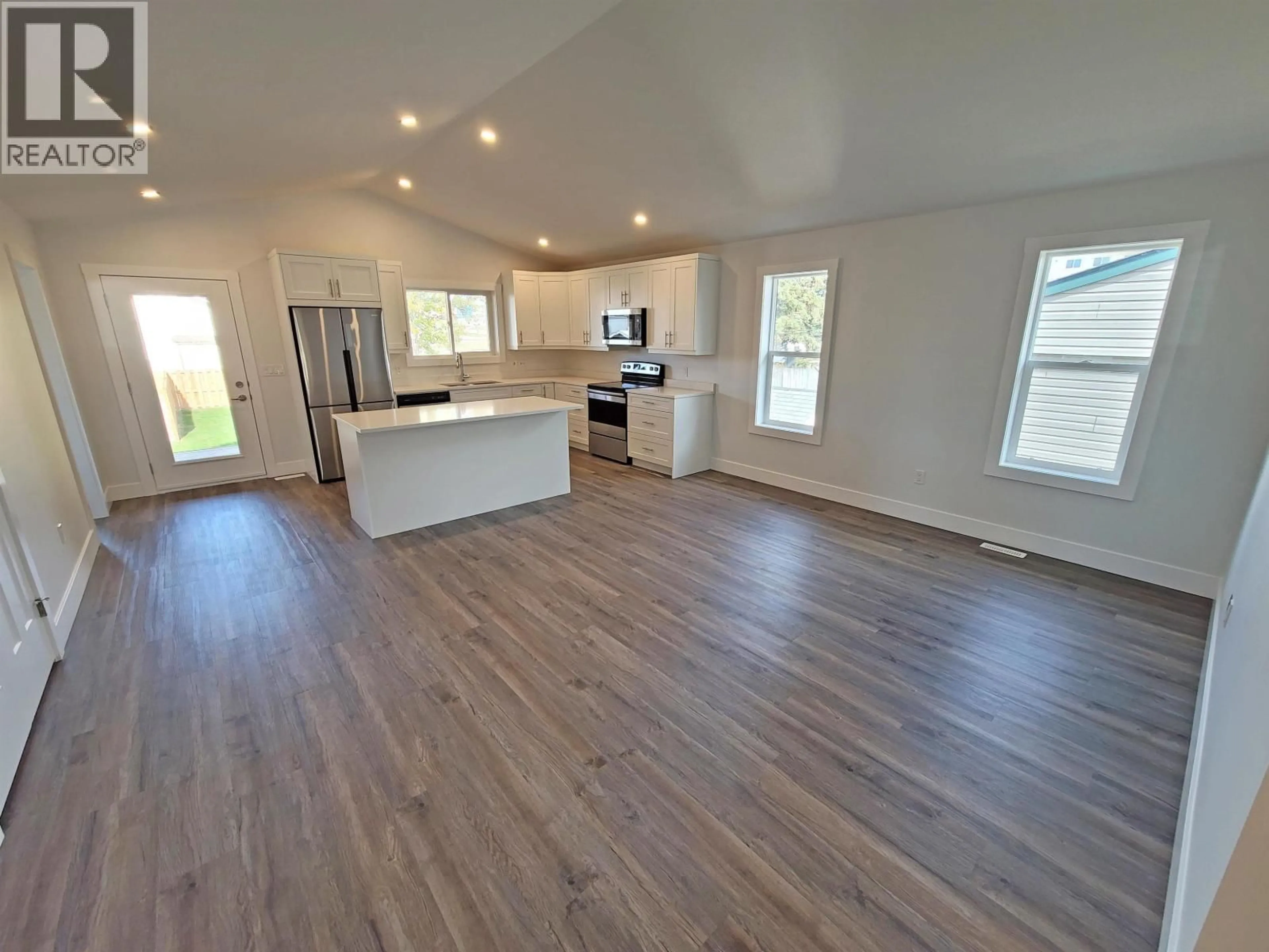 Open concept kitchen, wood/laminate floor for 8420 88 AVENUE, Fort St. John British Columbia V1J0S2