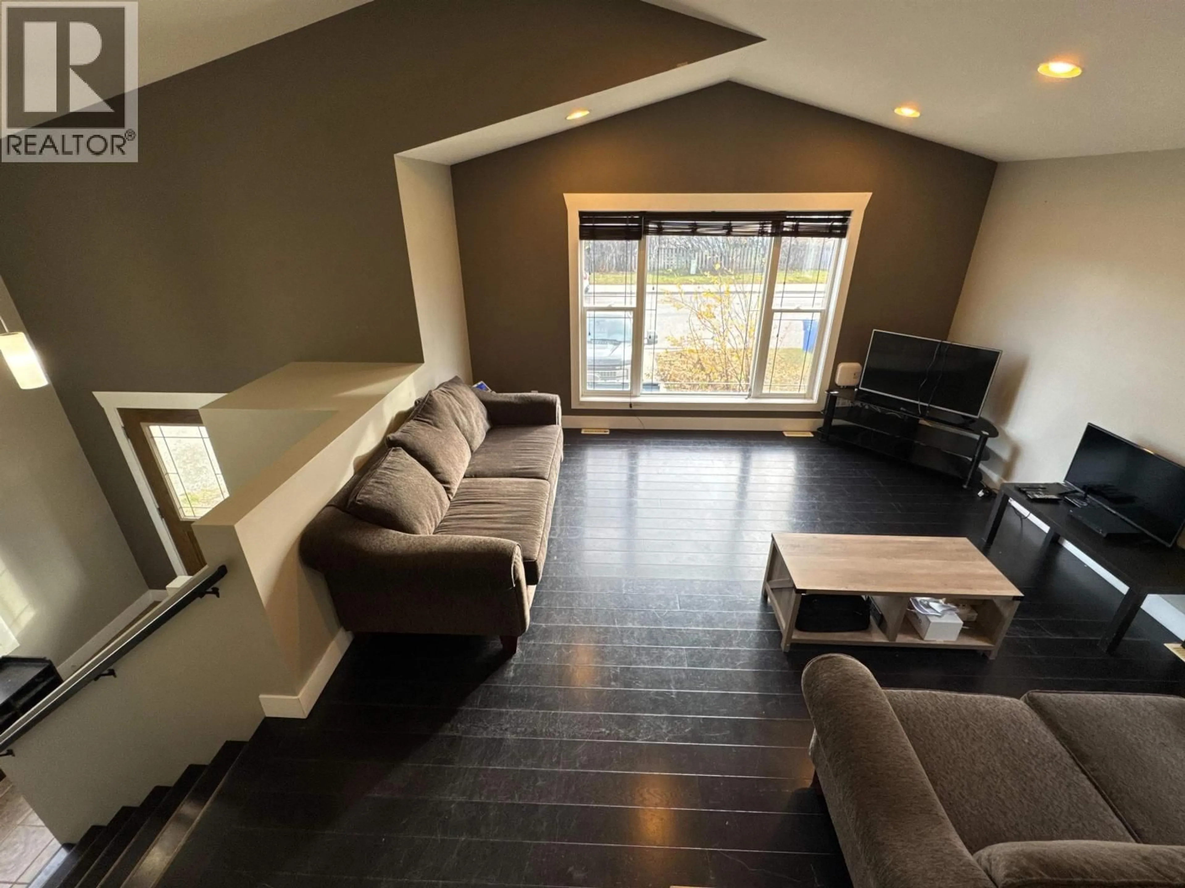 Living room with furniture, wood/laminate floor for 8312 85 AVENUE, Fort St. John British Columbia V1J0G3