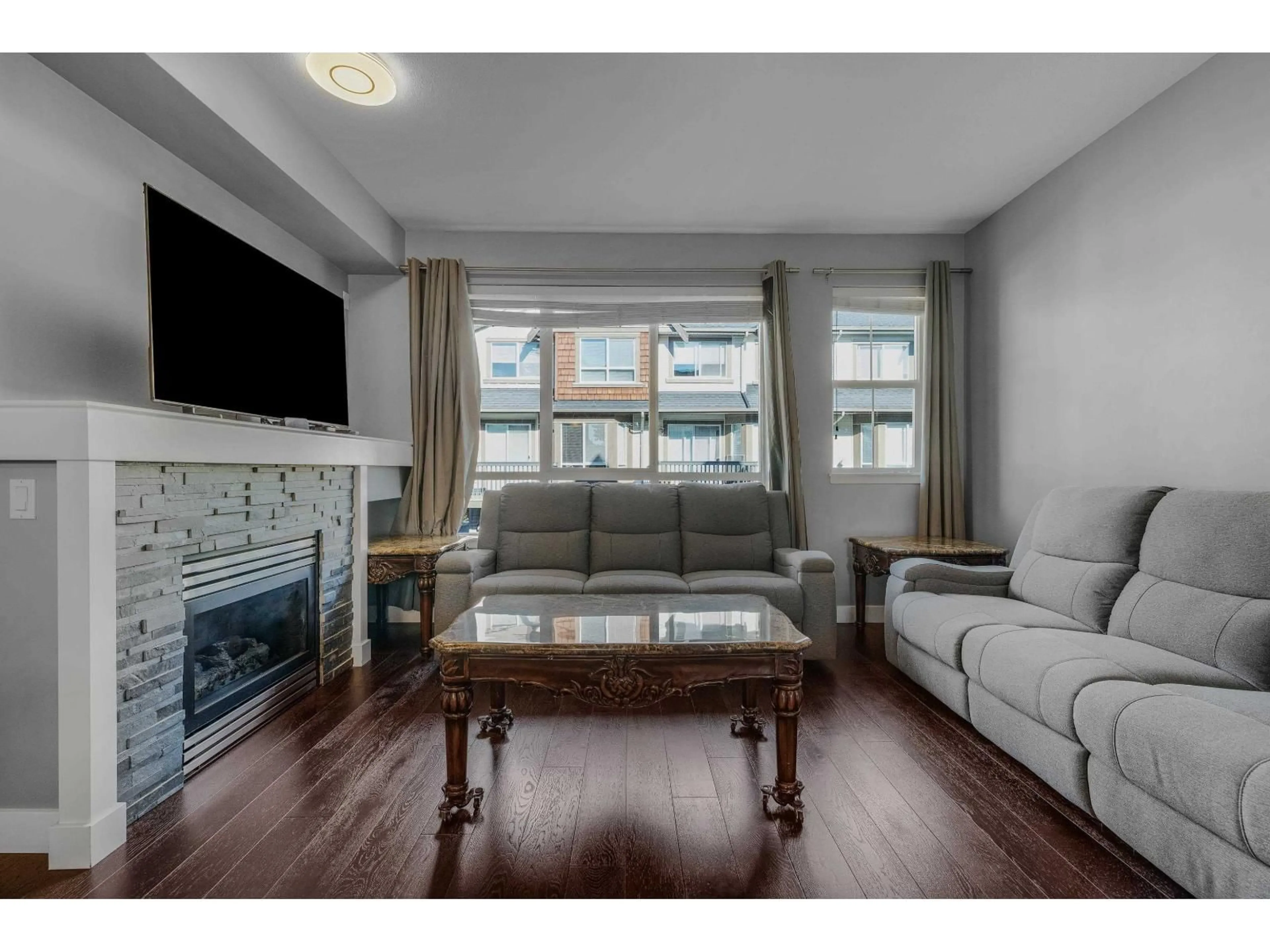 Living room with furniture, wood/laminate floor for 76 - 7155 189 STREET, Surrey British Columbia V4N5S8
