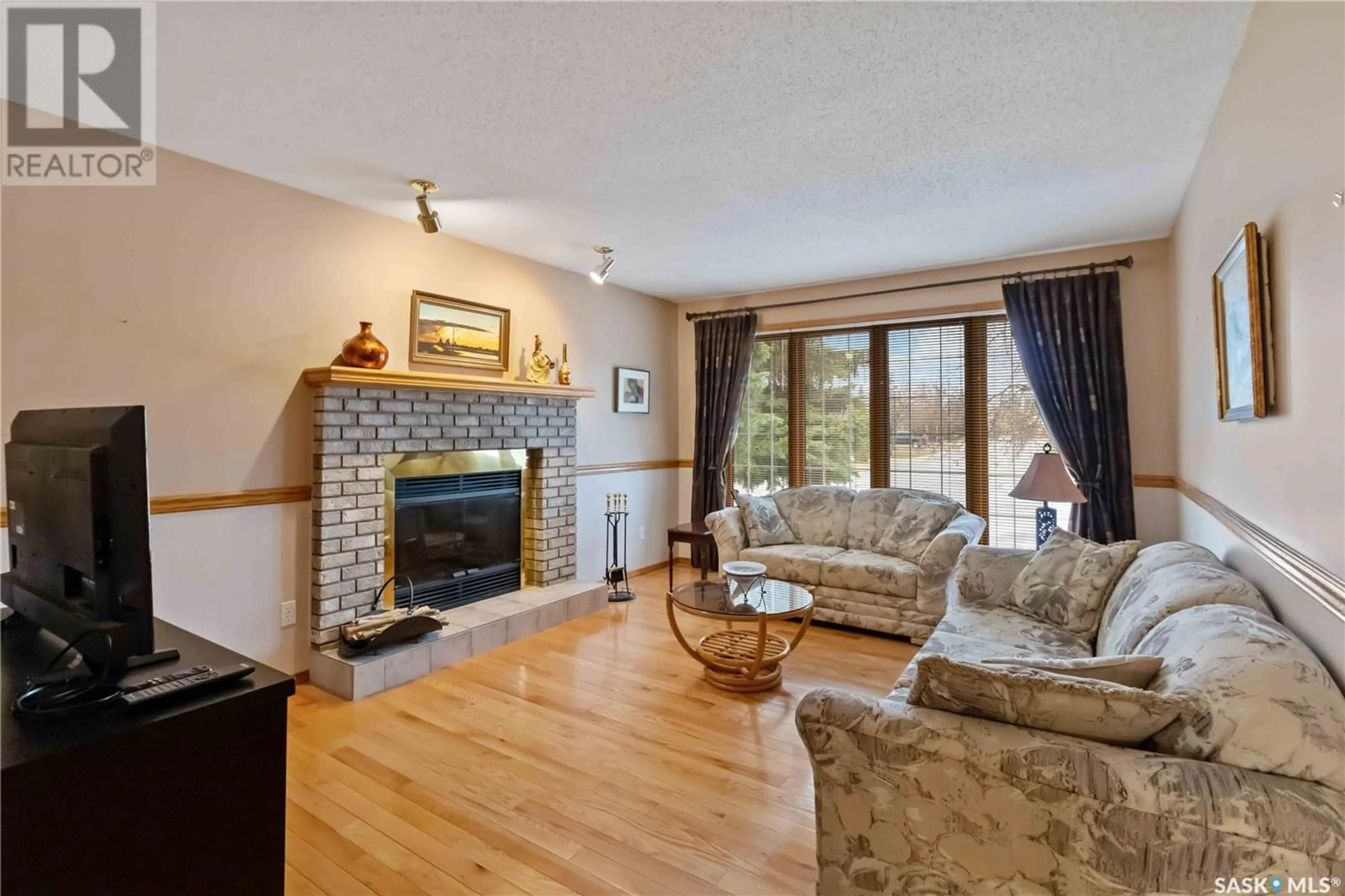 Living room with furniture, wood/laminate floor for 702 STEIGER PLACE, Saskatoon Saskatchewan S7N4K3