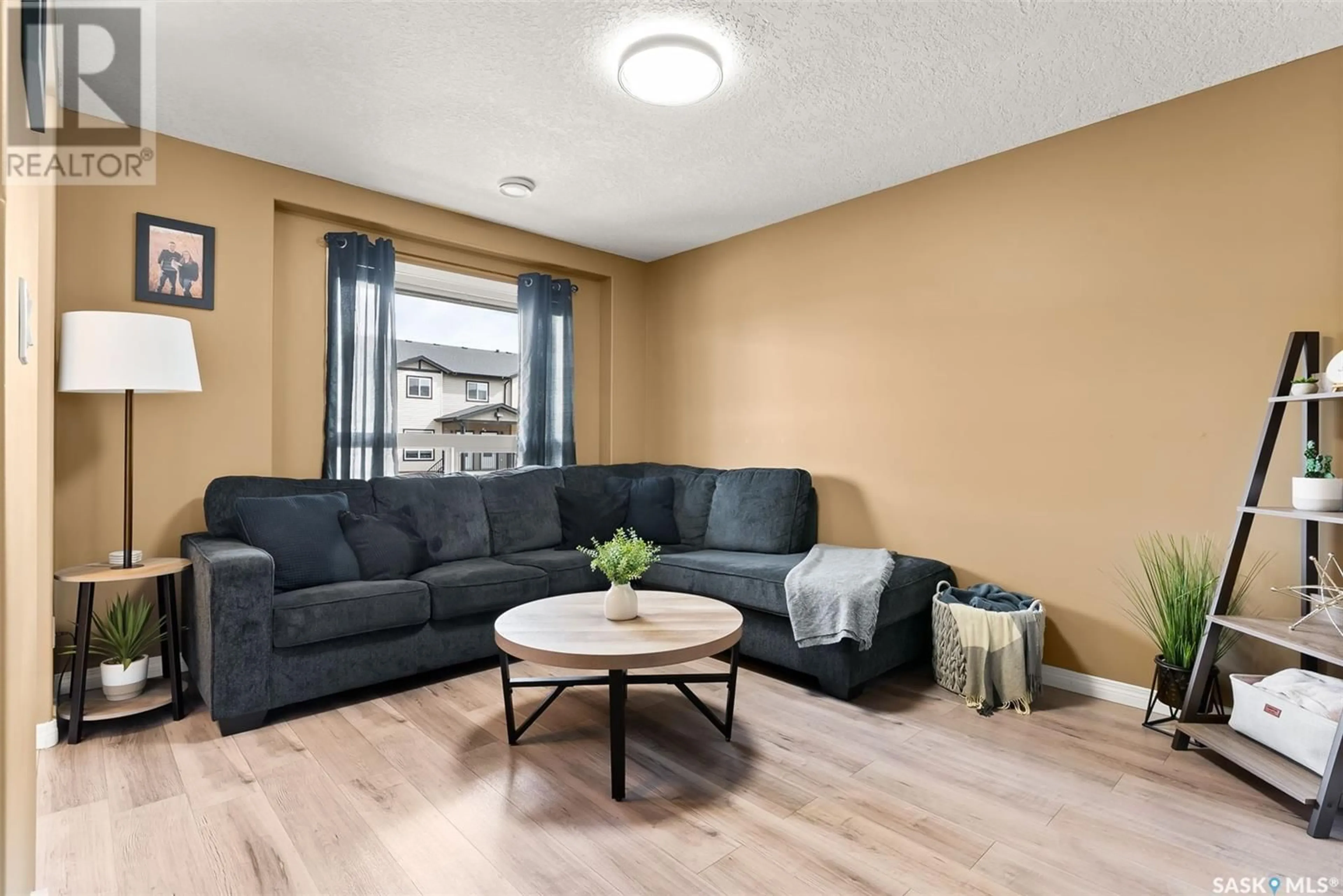 Living room with furniture, wood/laminate floor for 3806 - 717 DEWDNEY AVENUE, Regina Saskatchewan S4Z0A6