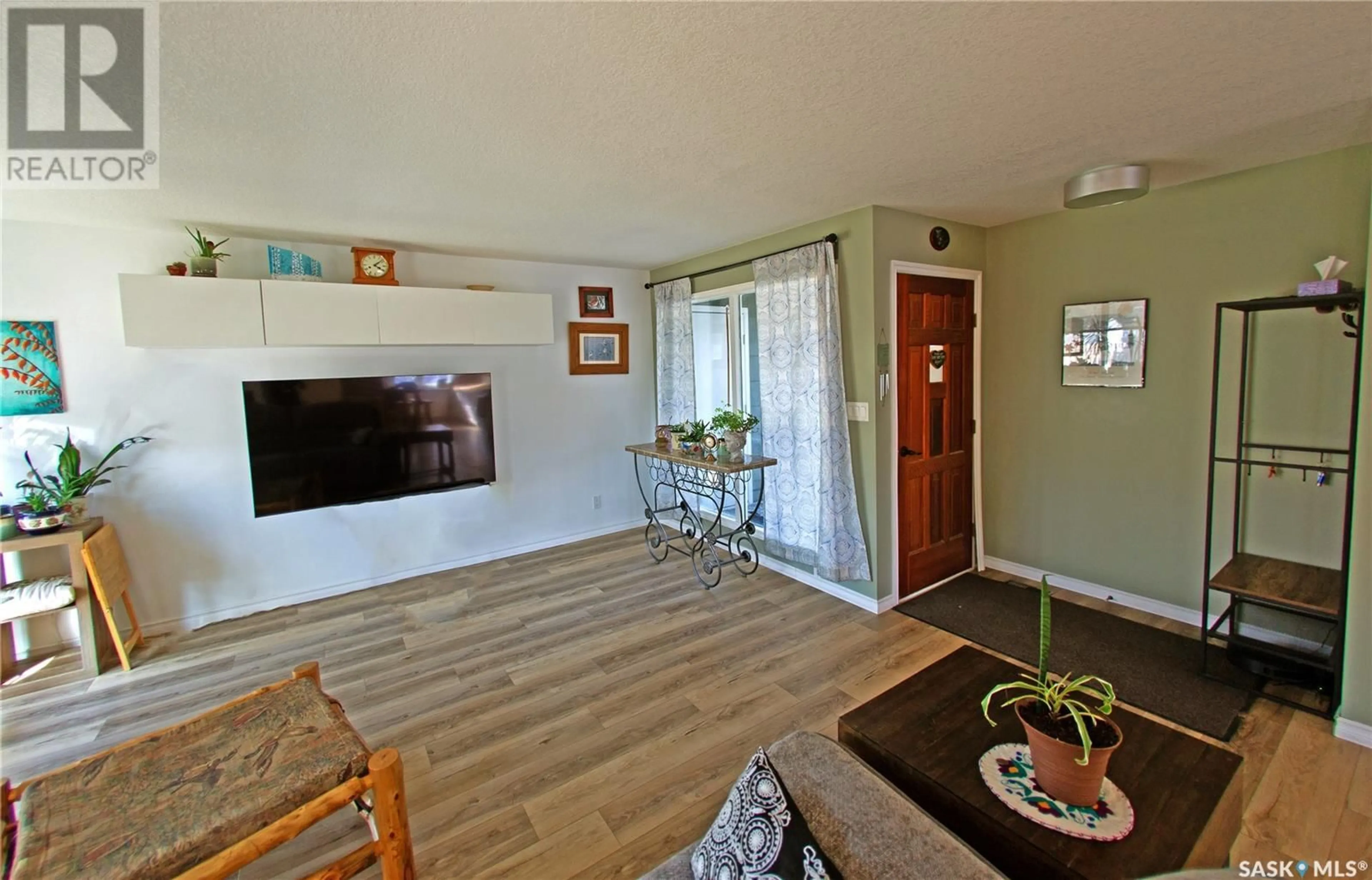 Living room with furniture, wood/laminate floor for 217 10TH AVENUE, Kindersley Saskatchewan S0L1S0