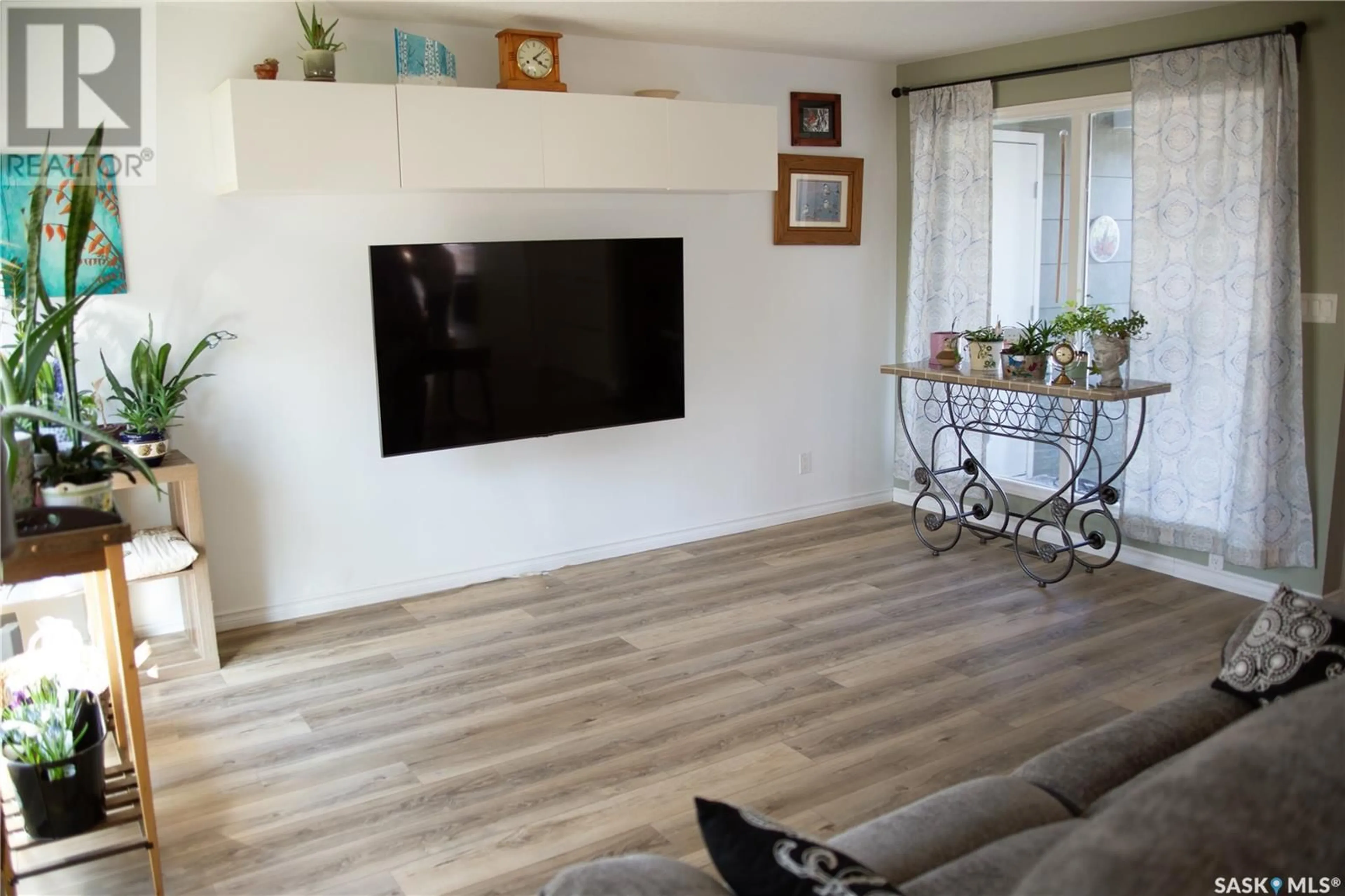 Living room with furniture, wood/laminate floor for 217 10TH AVENUE, Kindersley Saskatchewan S0L1S0