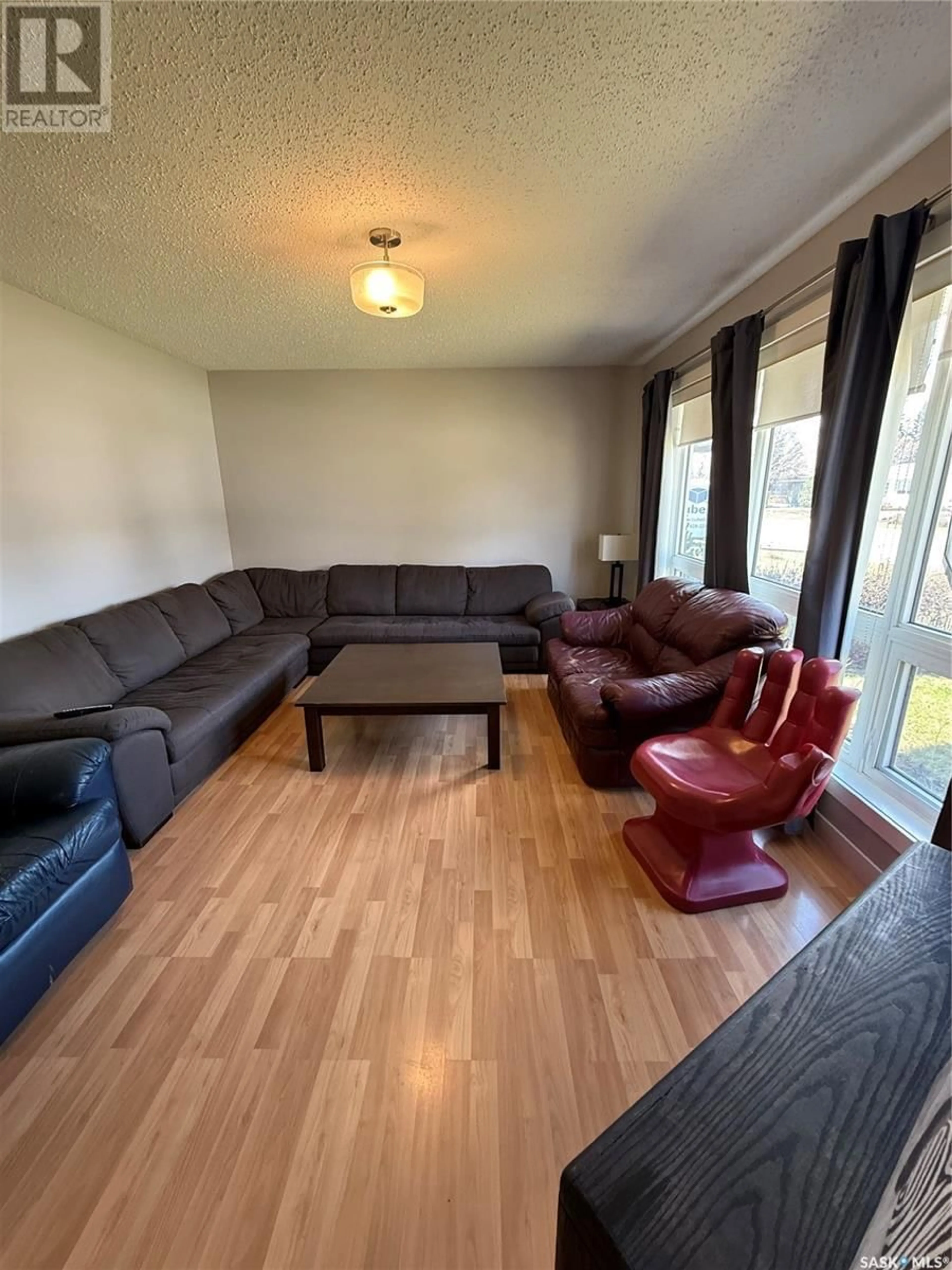Living room with furniture, wood/laminate floor for 56 LINDSAY DRIVE, Saskatoon Saskatchewan S7H3E1