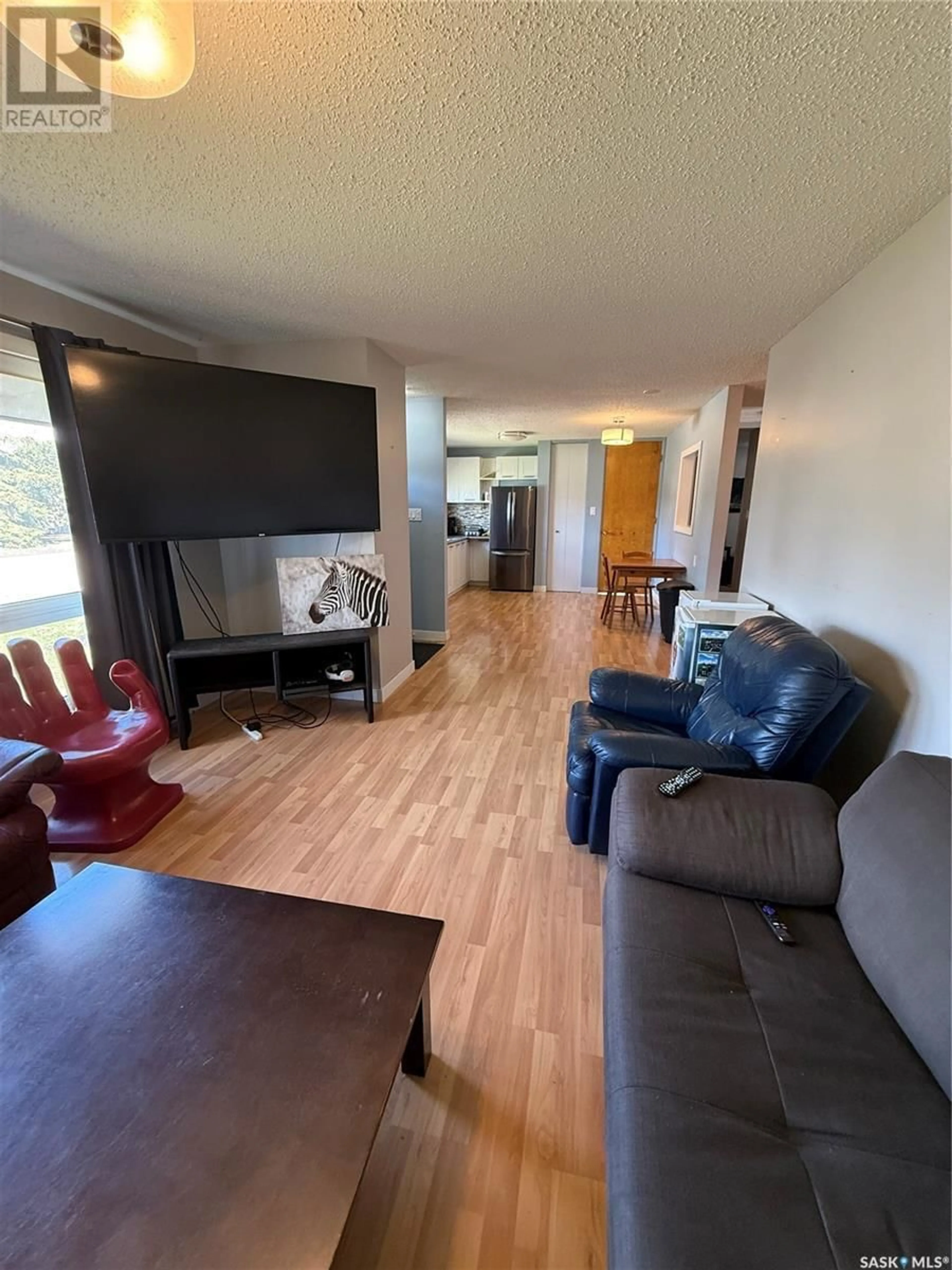 Living room with furniture, wood/laminate floor for 56 LINDSAY DRIVE, Saskatoon Saskatchewan S7H3E1