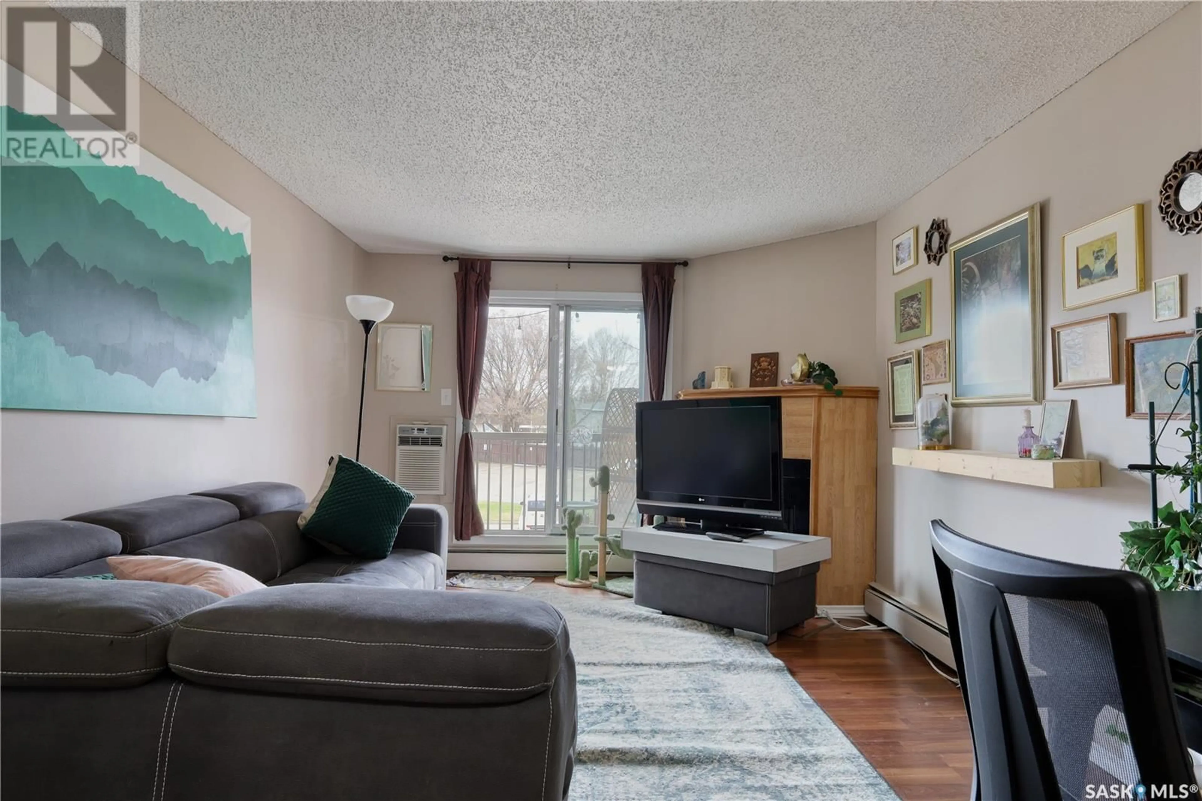 Living room with furniture, wood/laminate floor for 204 - 3308 33RD STREET, Saskatoon Saskatchewan S7L6X6