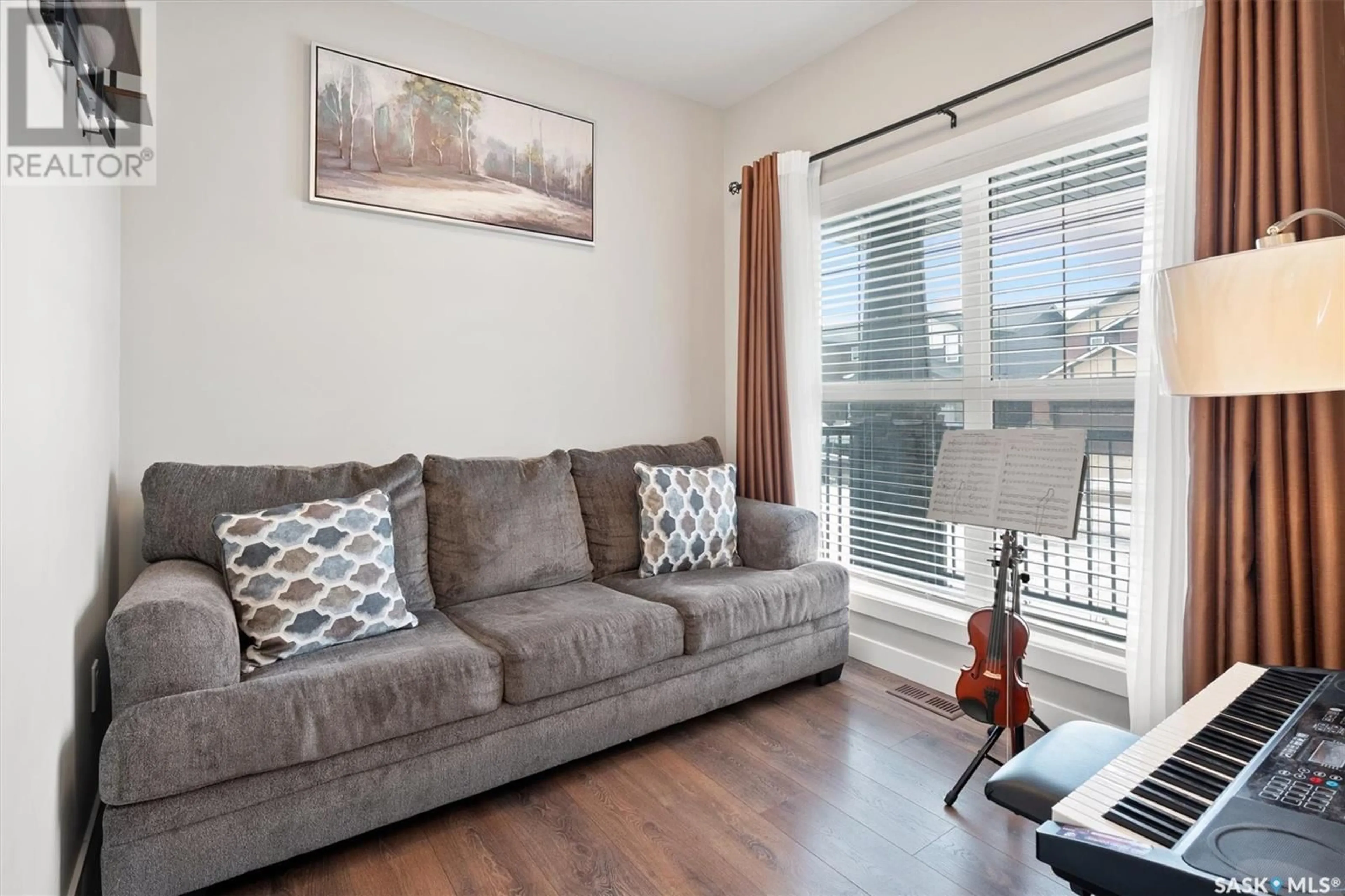 Living room with furniture, wood/laminate floor for 303 DELAINEY MANOR, Saskatoon Saskatchewan S7V0N4