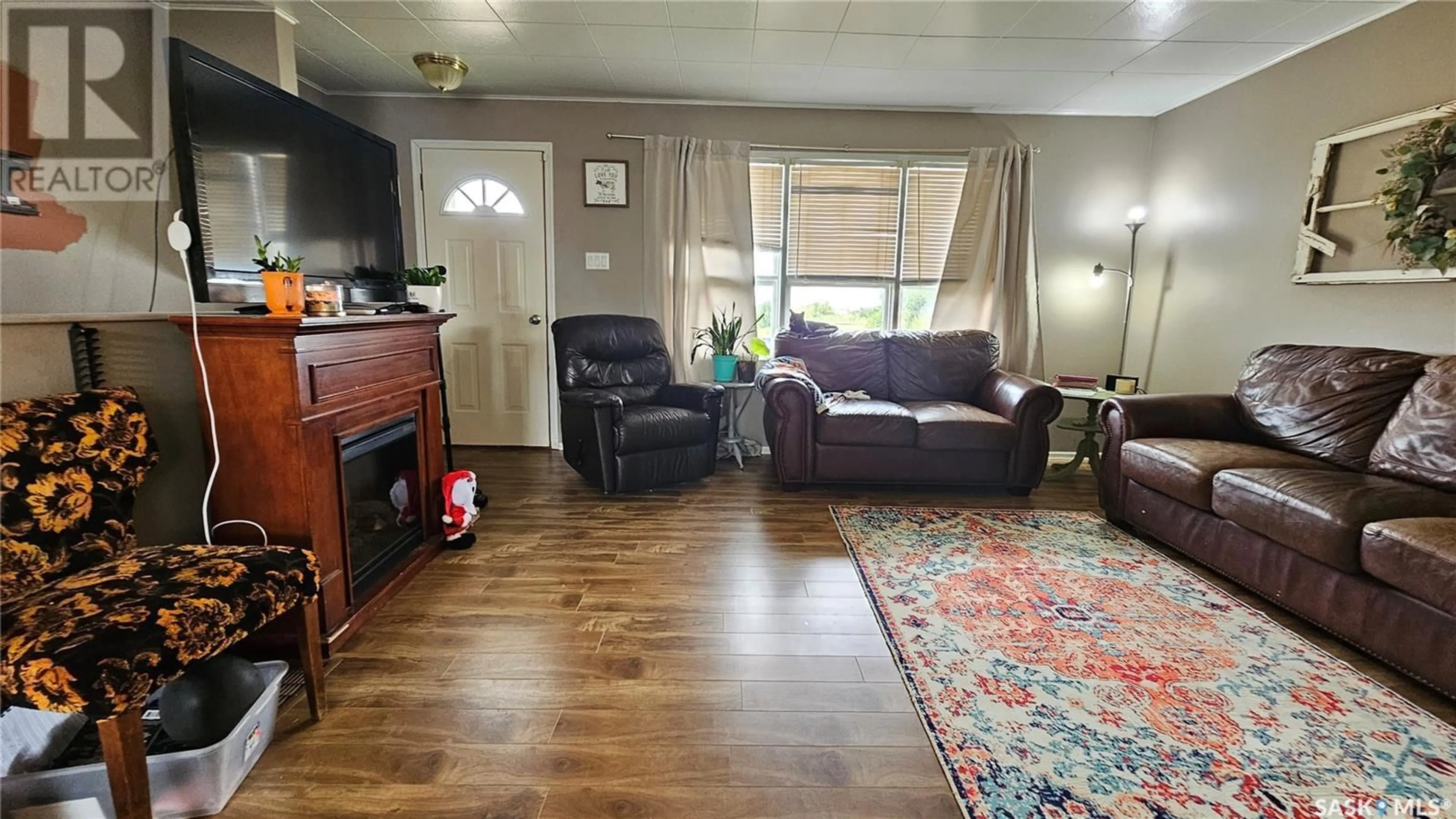 Living room with furniture, wood/laminate floor for 30 RAILWAY AVENUE, Success Saskatchewan S0N2R0