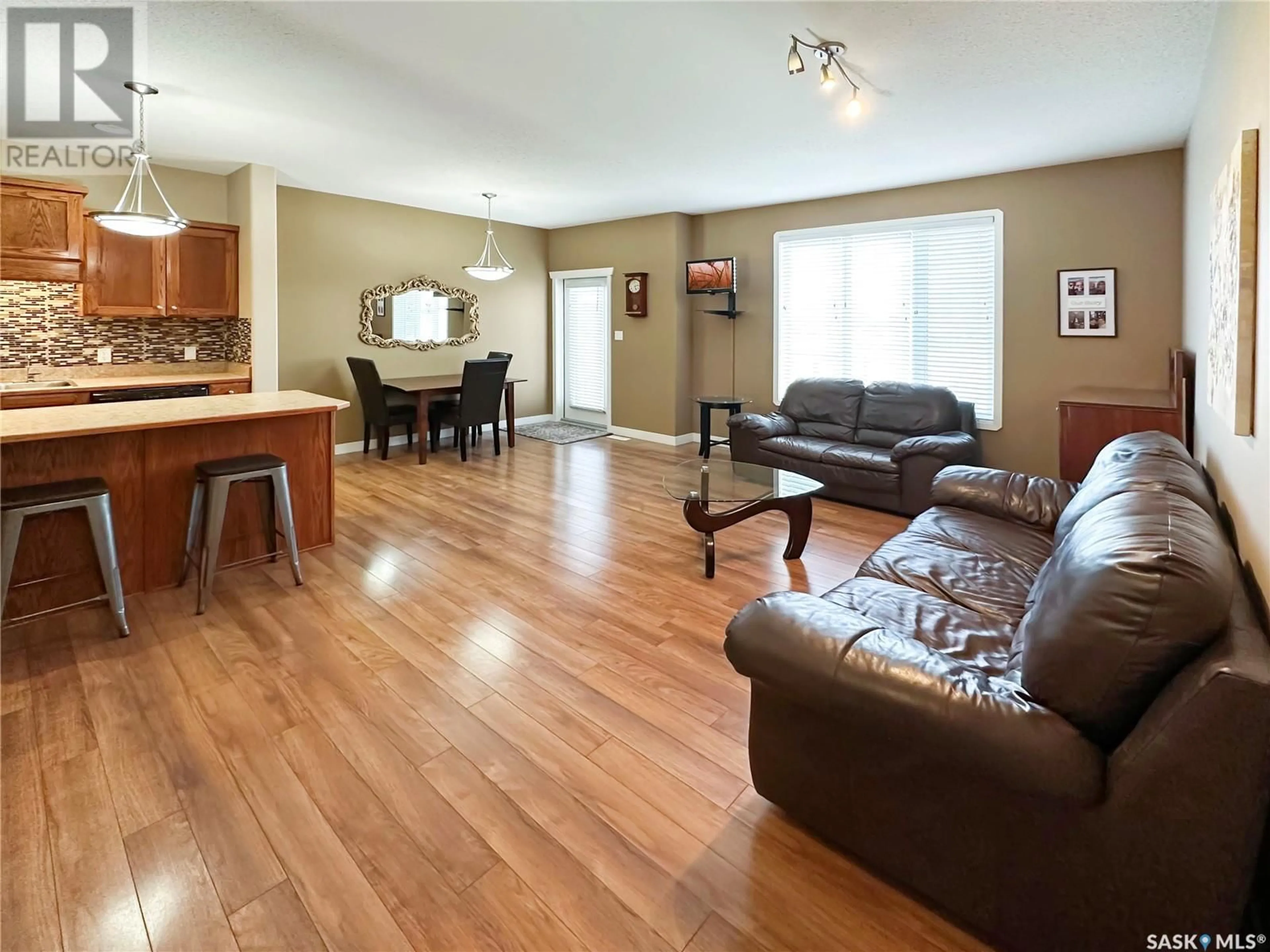 Living room with furniture, wood/laminate floor for E - 5701 MCINTOSH STREET, Swift Current Saskatchewan S9H1H7