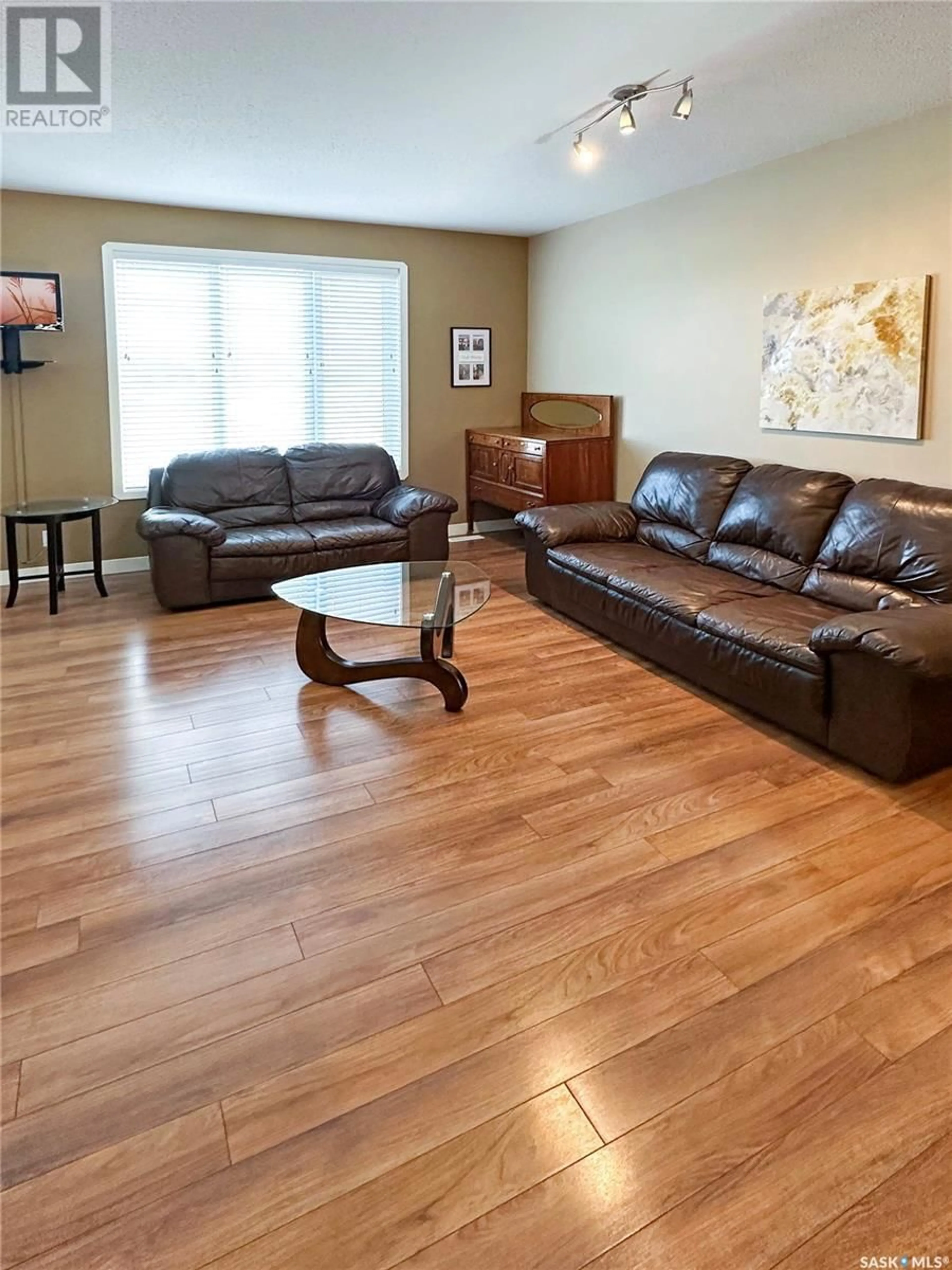 Living room with furniture, wood/laminate floor for E - 5701 MCINTOSH STREET, Swift Current Saskatchewan S9H1H7