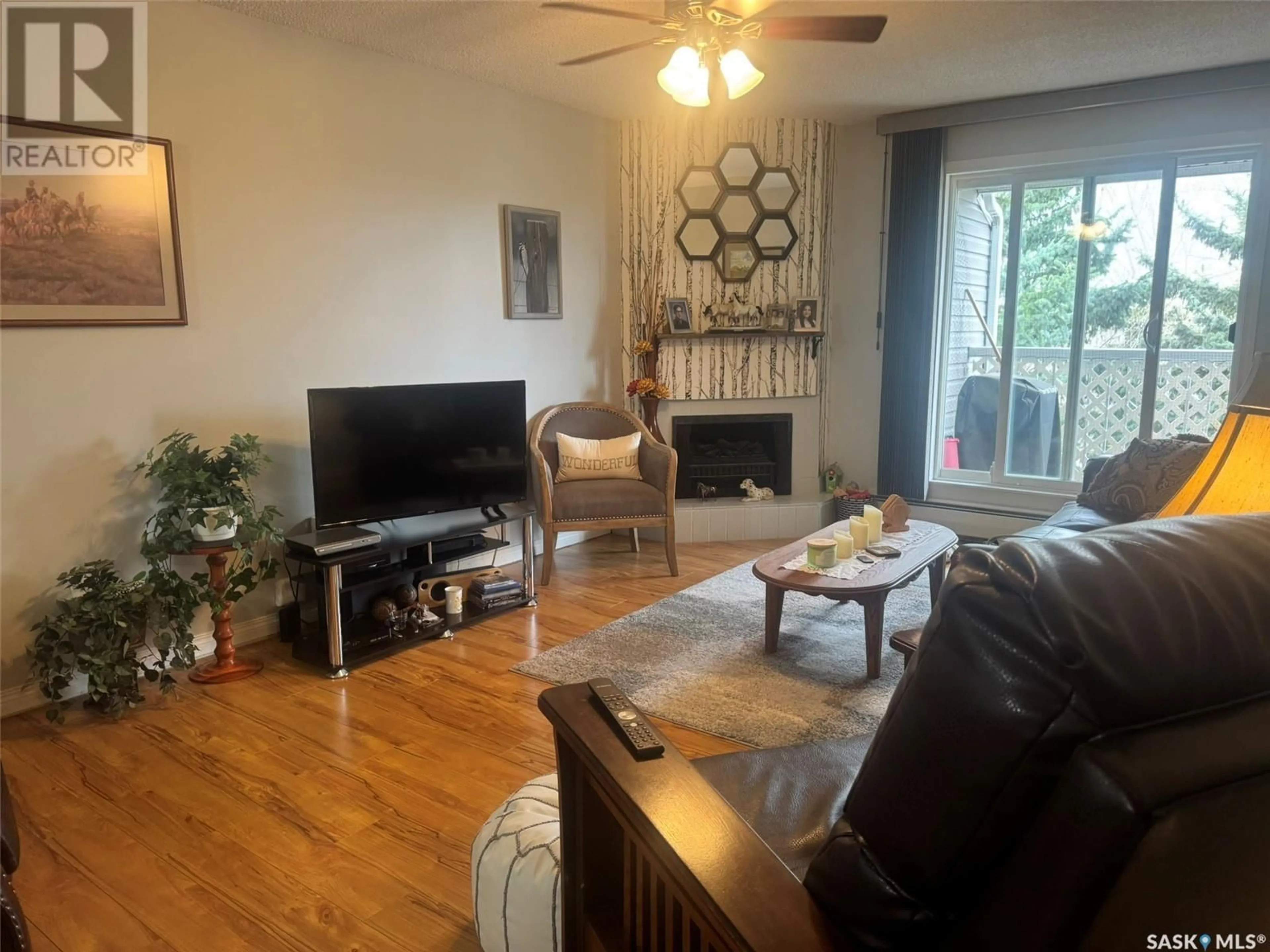 Living room with furniture, wood/laminate floor for 303 1808 EAGLESHAM AVENUE, Weyburn Saskatchewan S4H3A8