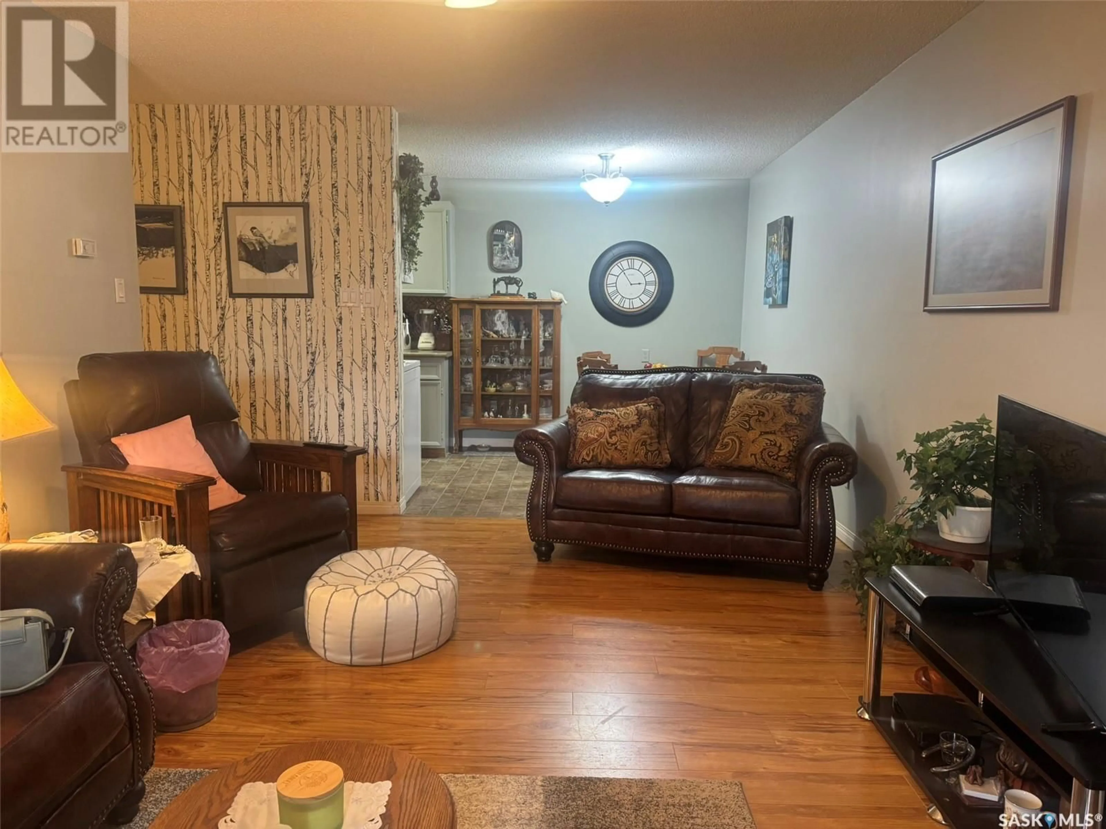 Living room with furniture, wood/laminate floor for 303 1808 EAGLESHAM AVENUE, Weyburn Saskatchewan S4H3A8