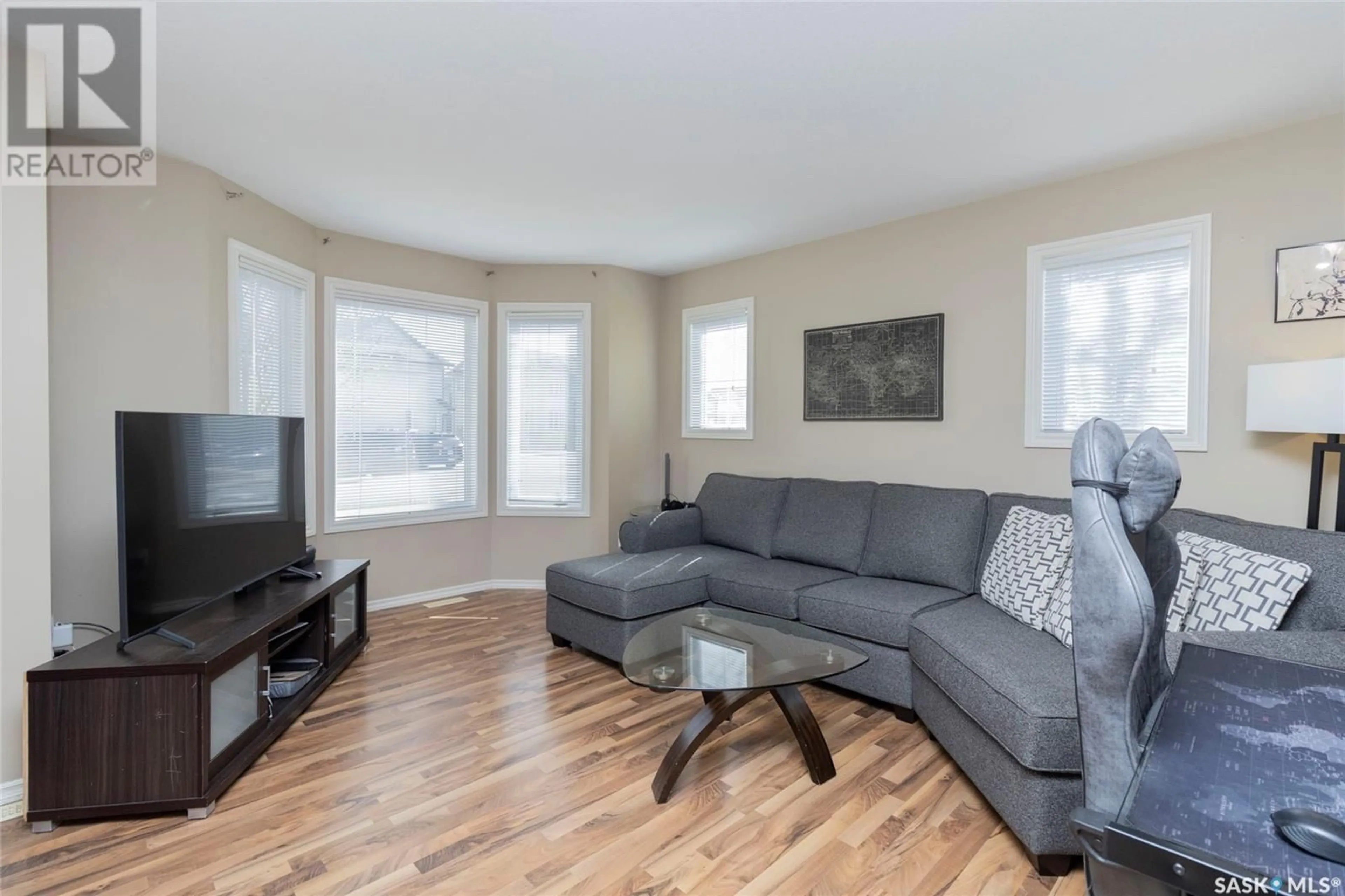 Living room with furniture, wood/laminate floor for 303 - 401 SLIMMON PLACE, Saskatoon Saskatchewan S7V0A8
