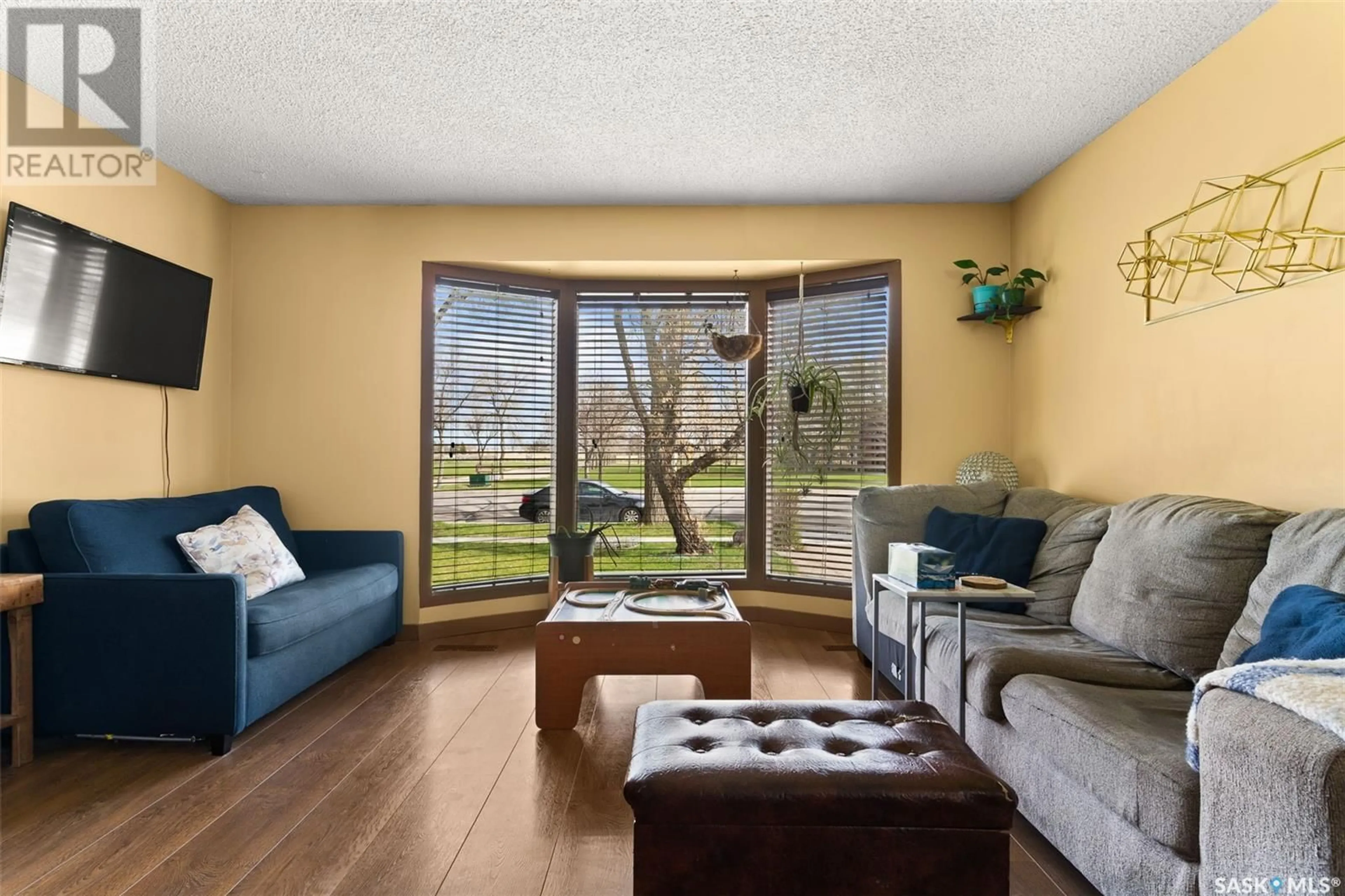 Living room with furniture, wood/laminate floor for 3308 GRANT ROAD, Regina Saskatchewan S4S5H5