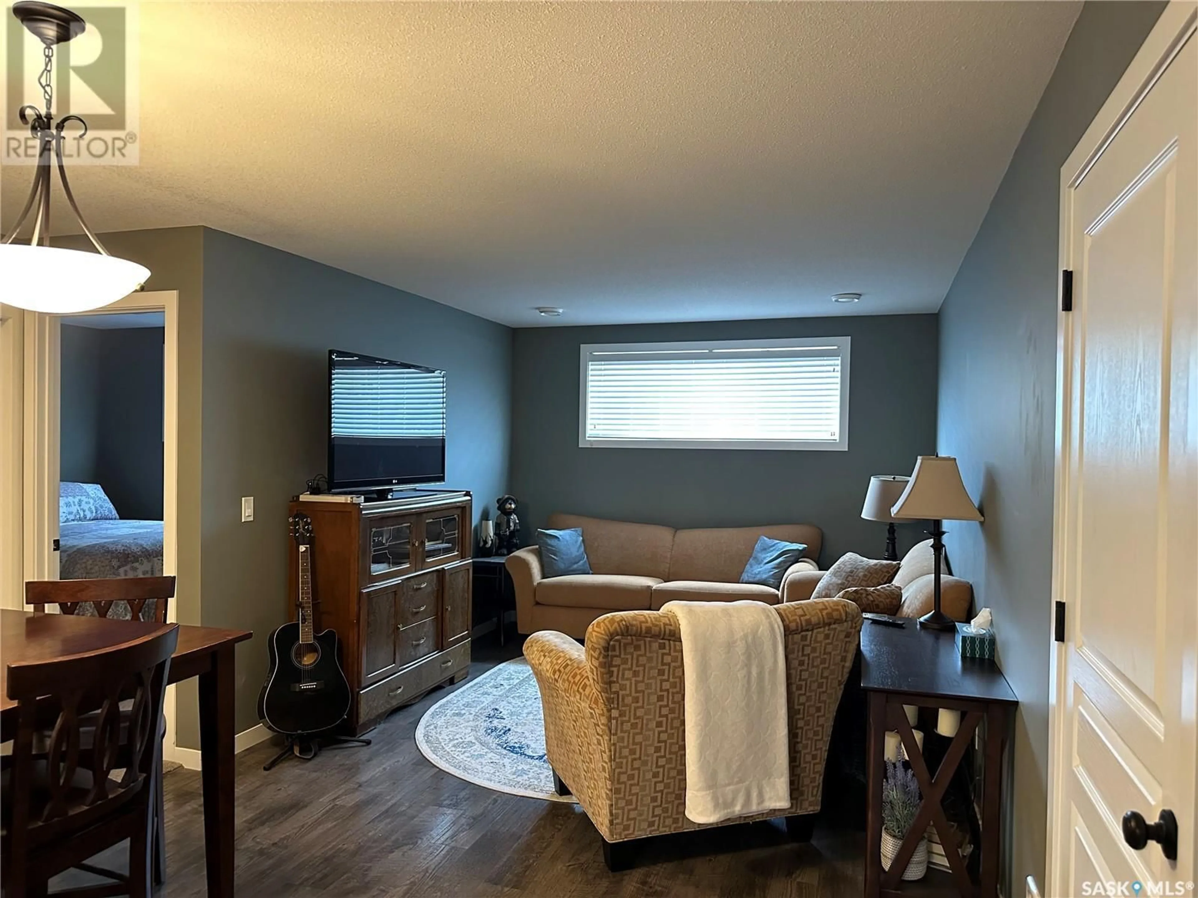Living room with furniture, wood/laminate floor for 39 5004 JAMES HILL ROAD, Regina Saskatchewan S4W0E8